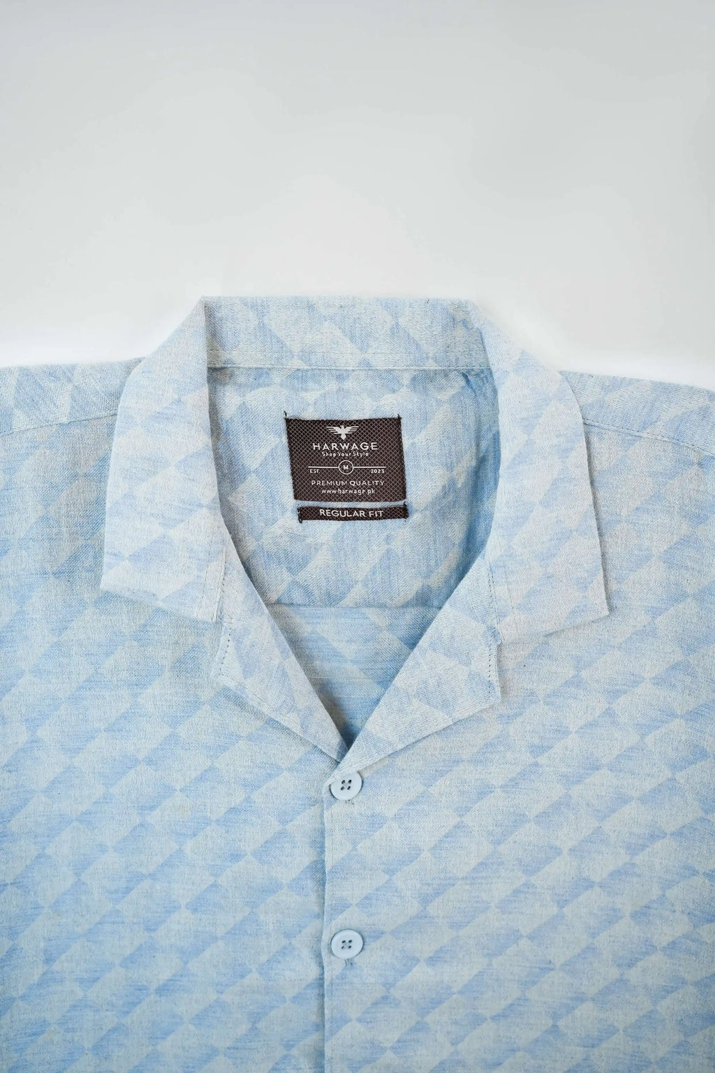 Light blue patterned shirt with a brand label