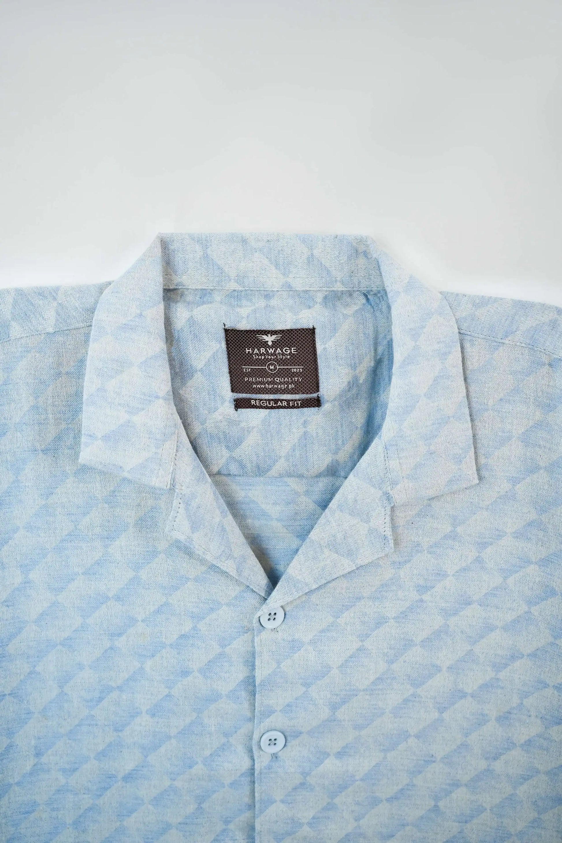 Light blue patterned shirt with a brand label