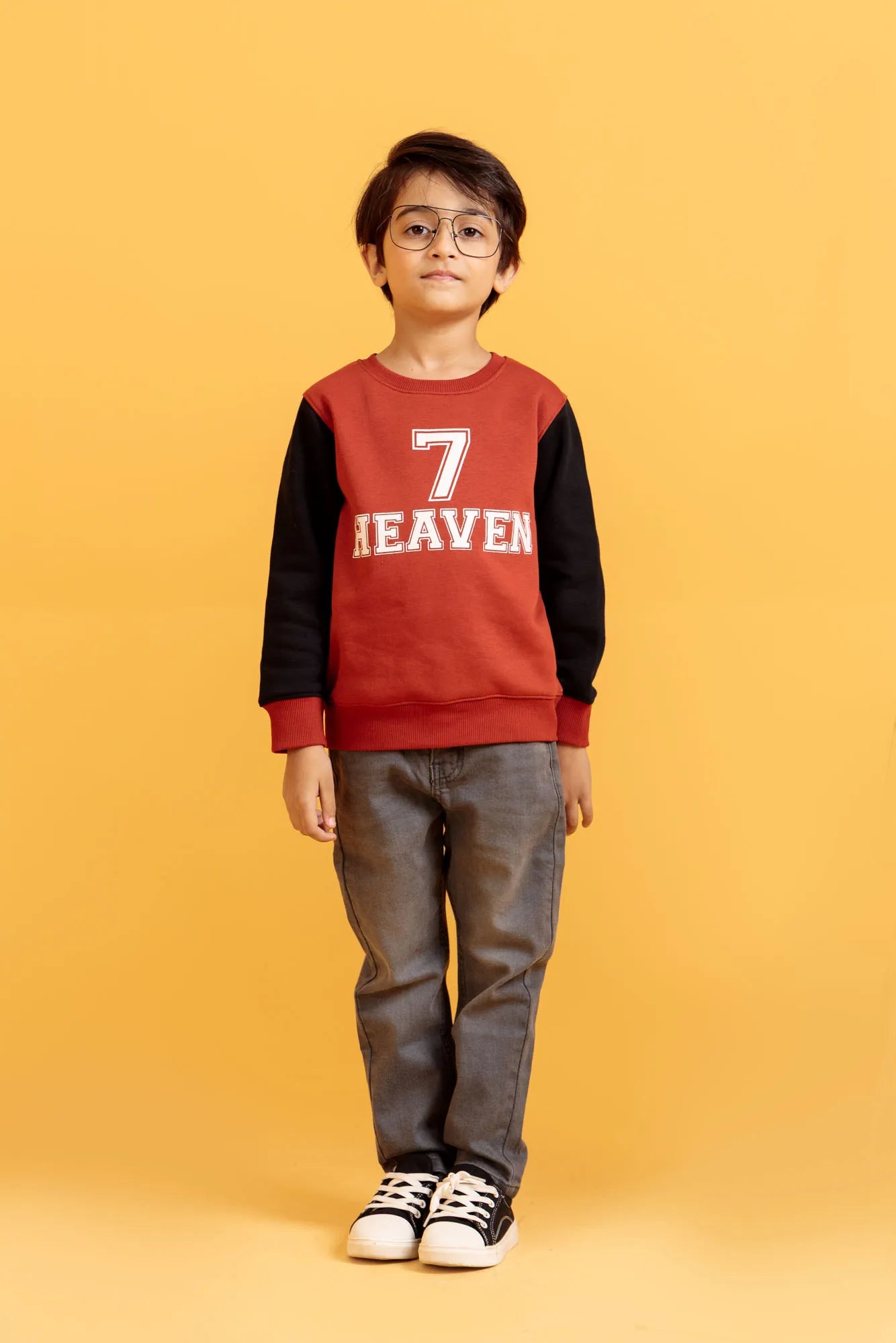 Little boy wearing a Sweatshirt in Orange Rust with jeans