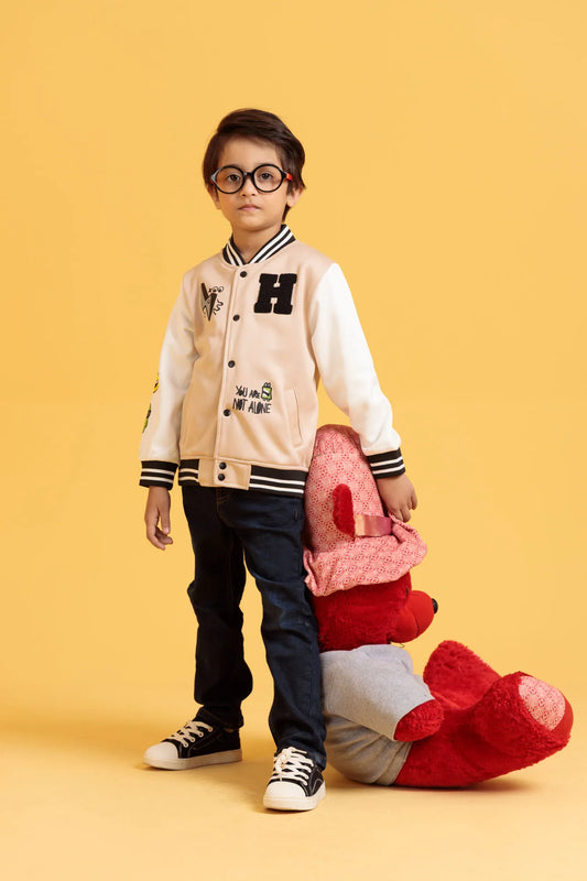 Little boy wearing a baseball jacket in a turtledove holding a red plush toy