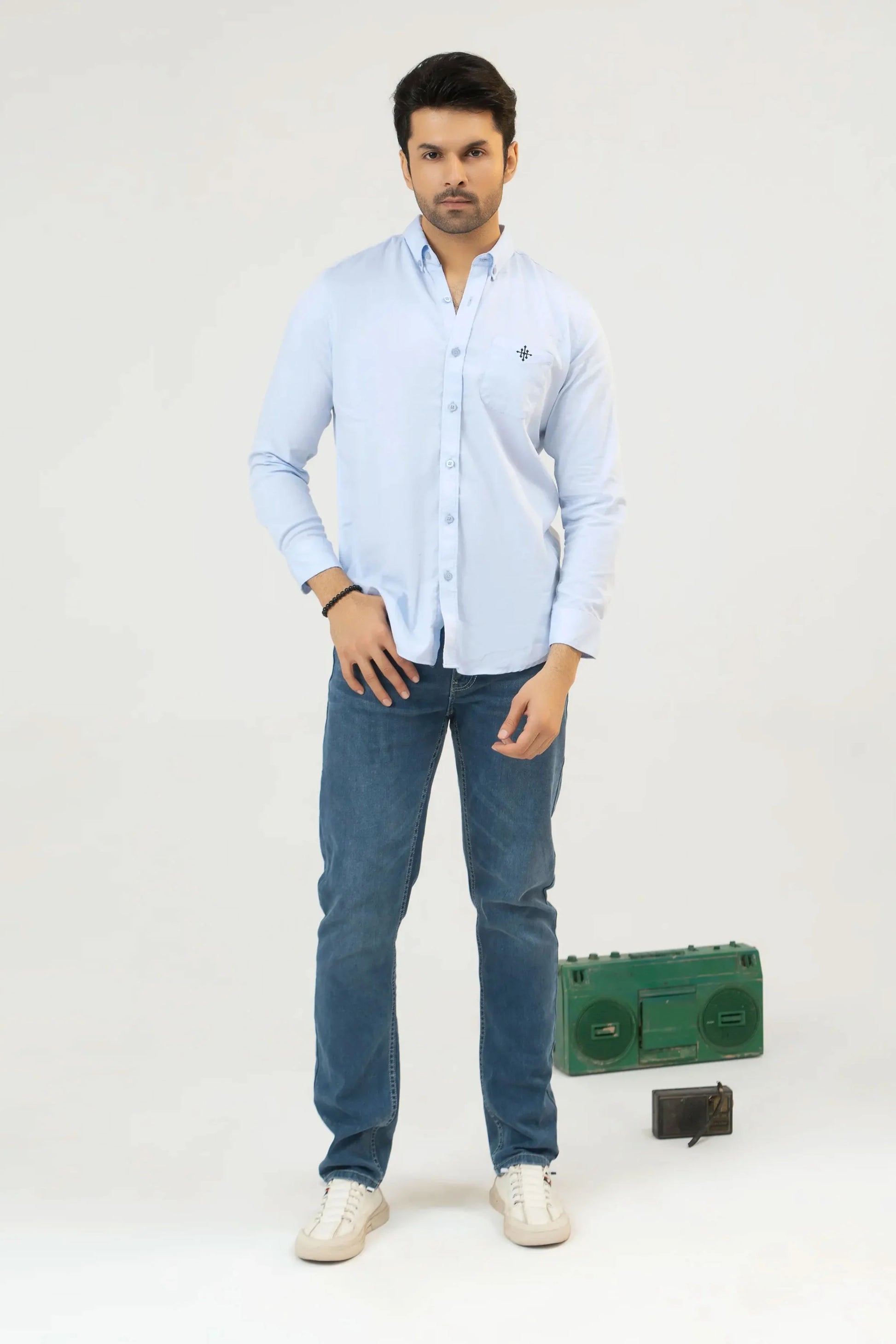 Man wearing a light blue shirt and jeans
