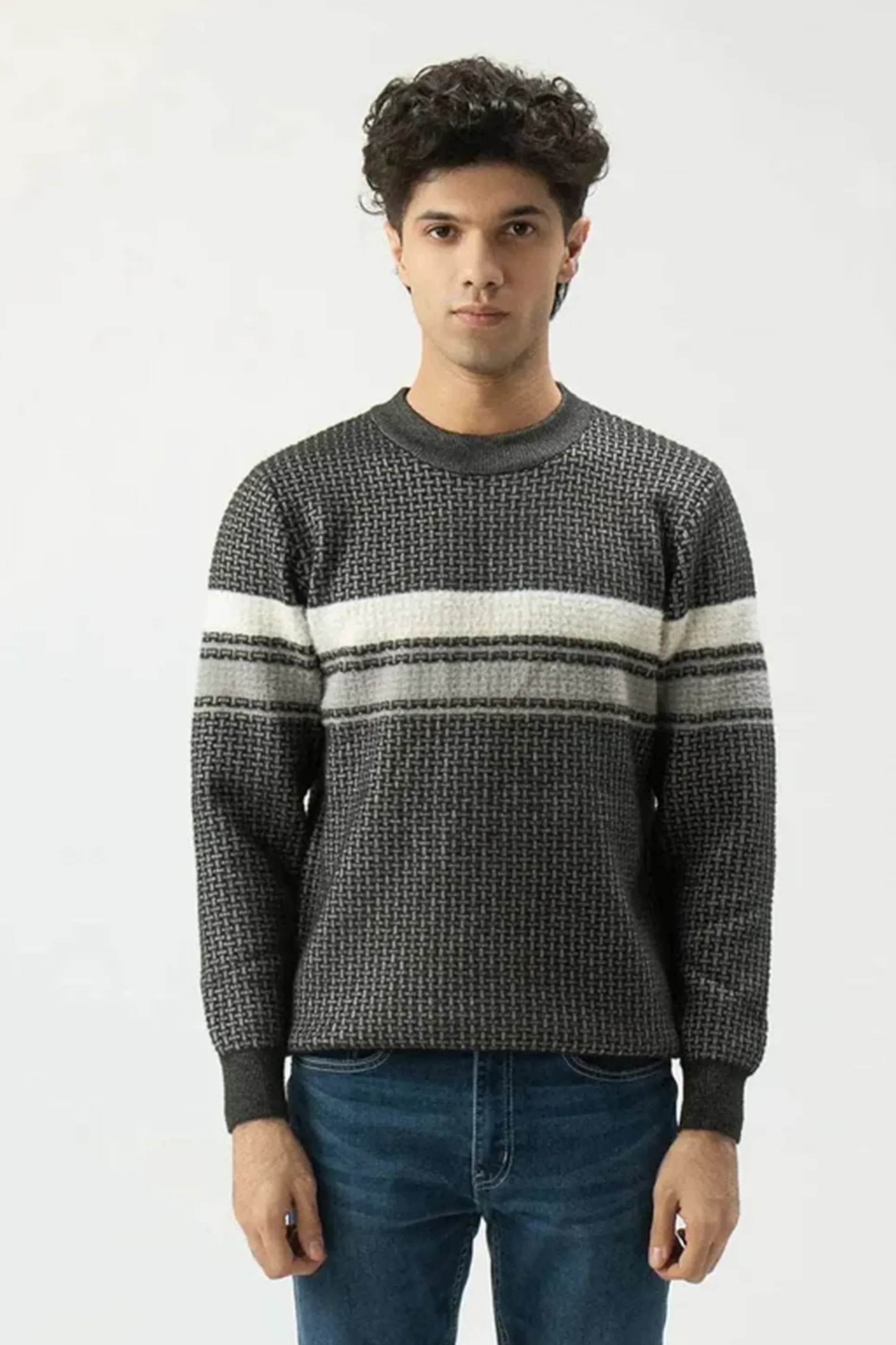 Man wearing a patterned sweater with horizontal stripes on a white background