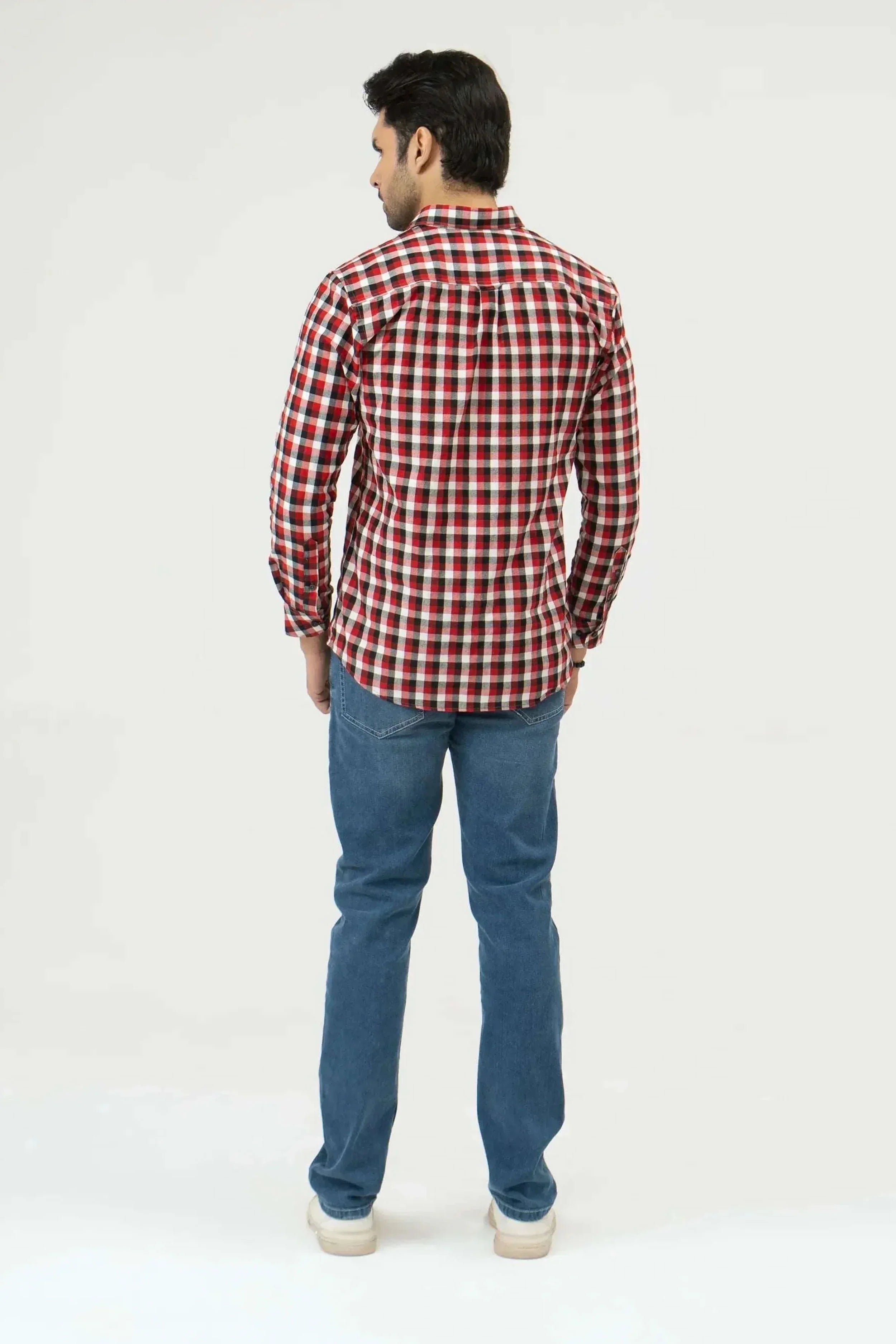 Man wearing a red and white checkered shirt and blue jeans