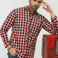 Man wearing a red and white checkered shirt with a vintage red television set 
