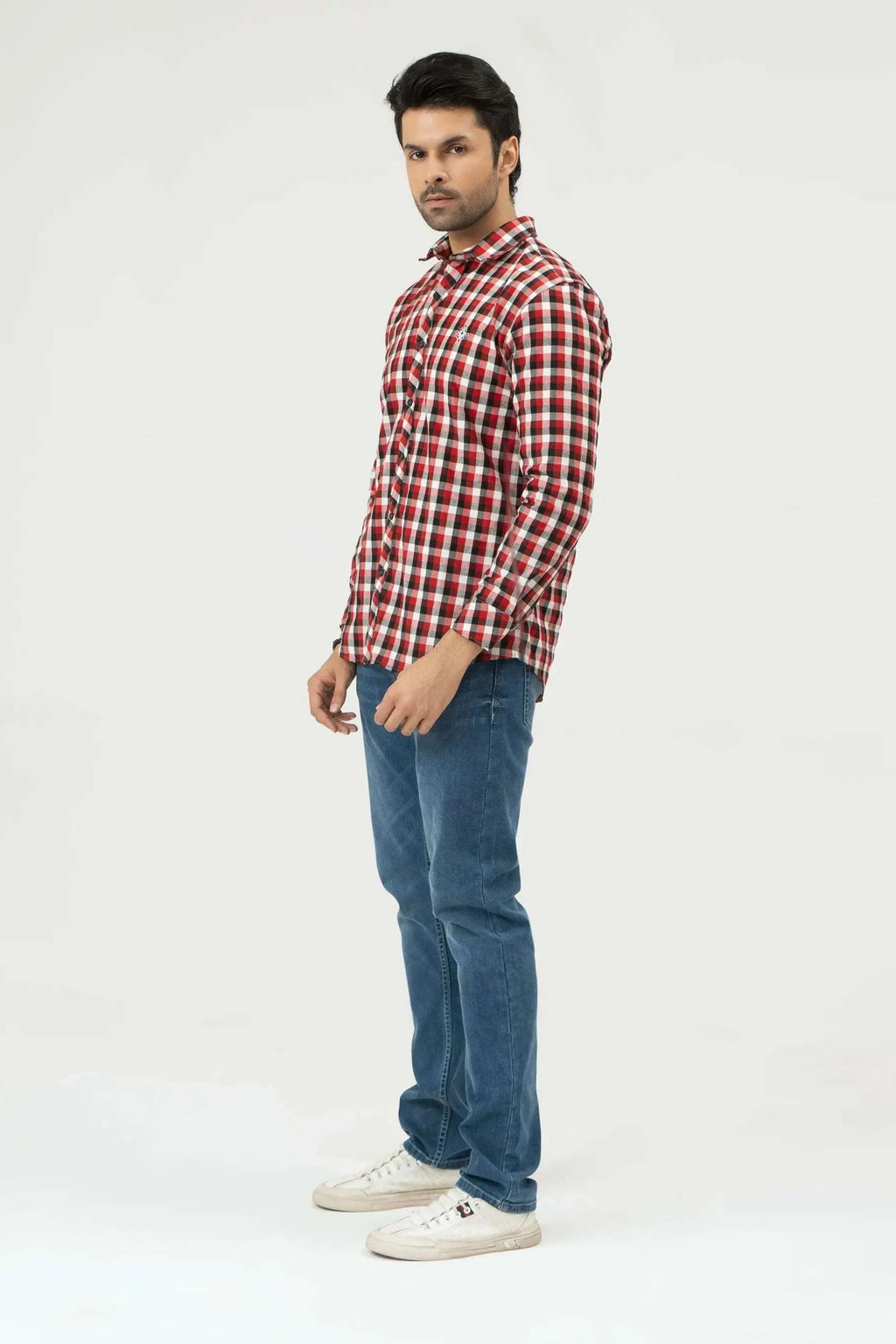 Man wearing a red and white checkered shirt with blue jeans