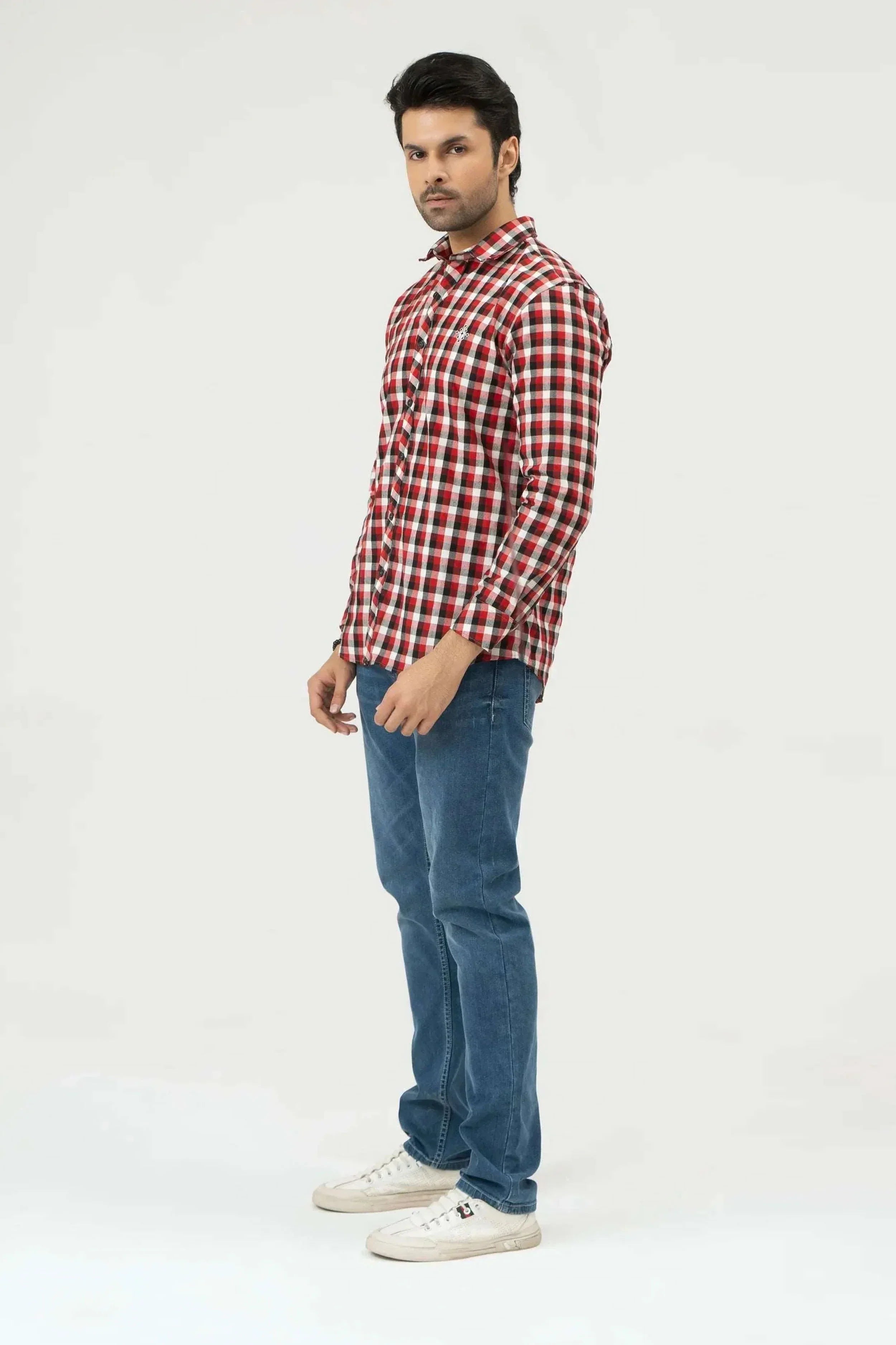 Man wearing a red and white checkered shirt with blue jeans