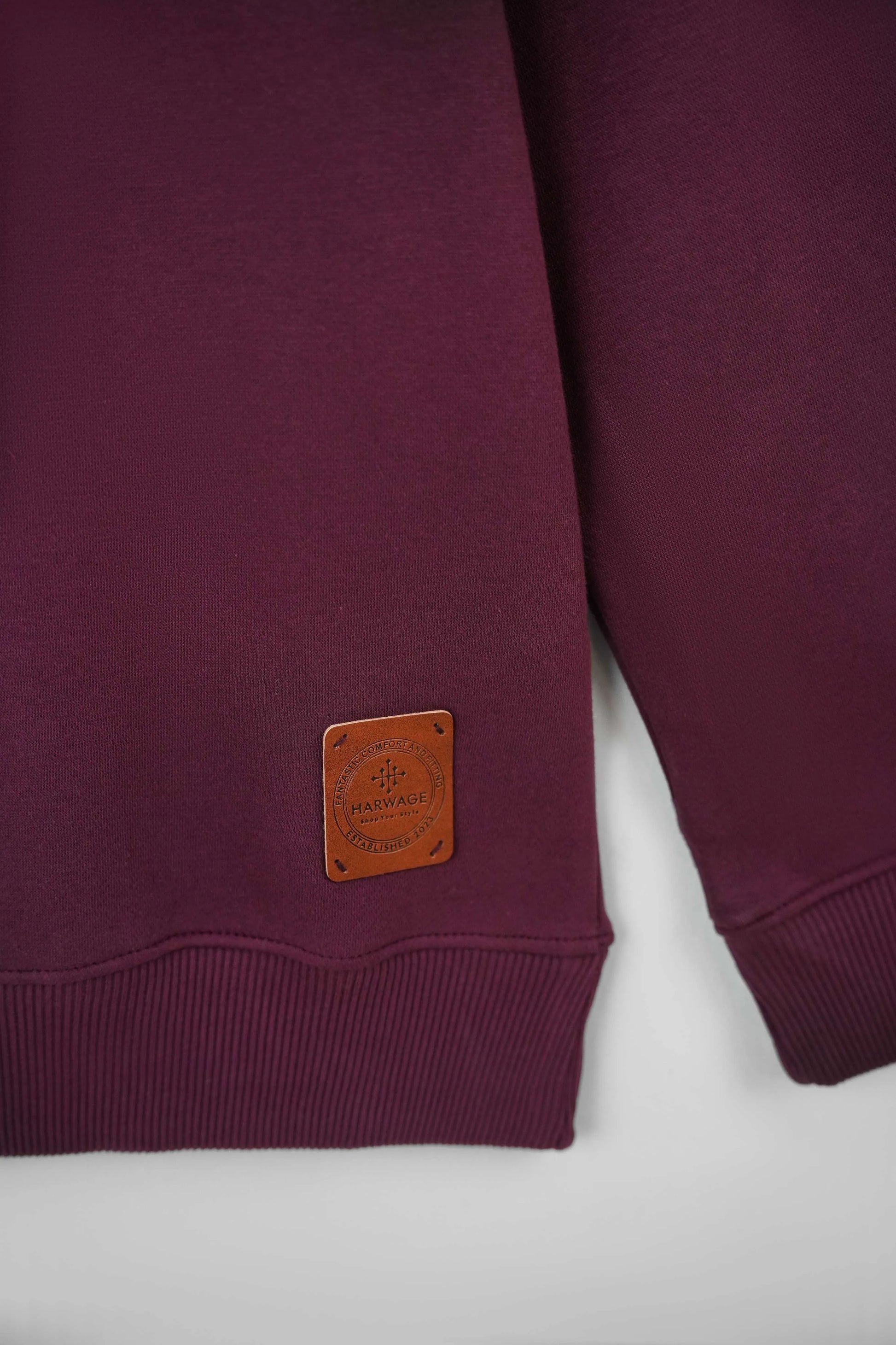 Maroon sweatshirt with a brown leather patch on a white background