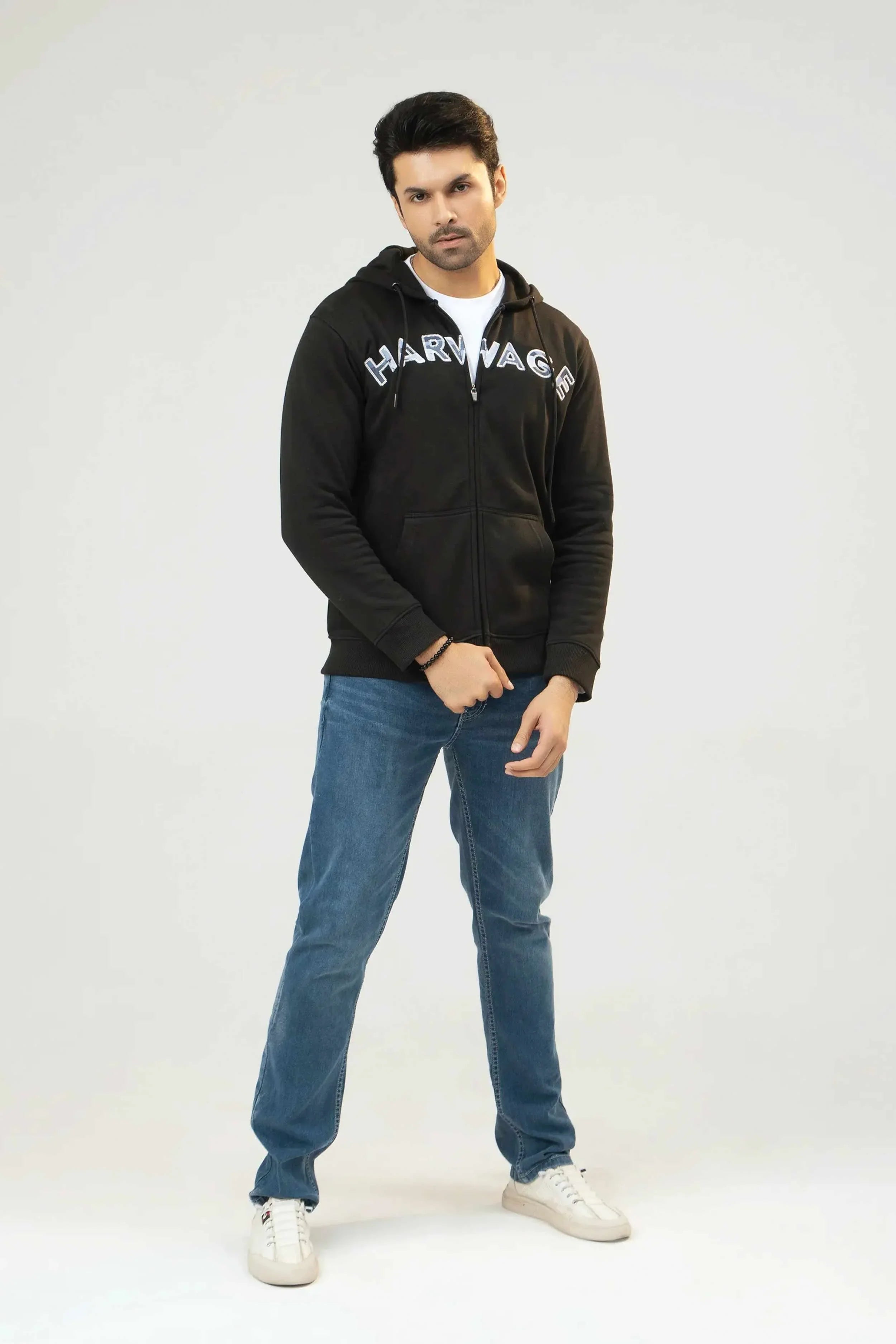 Men’s Black Tie-Dye Camouflage Hoodie with 'Harvey' branding, blue jeans, and white sneakers