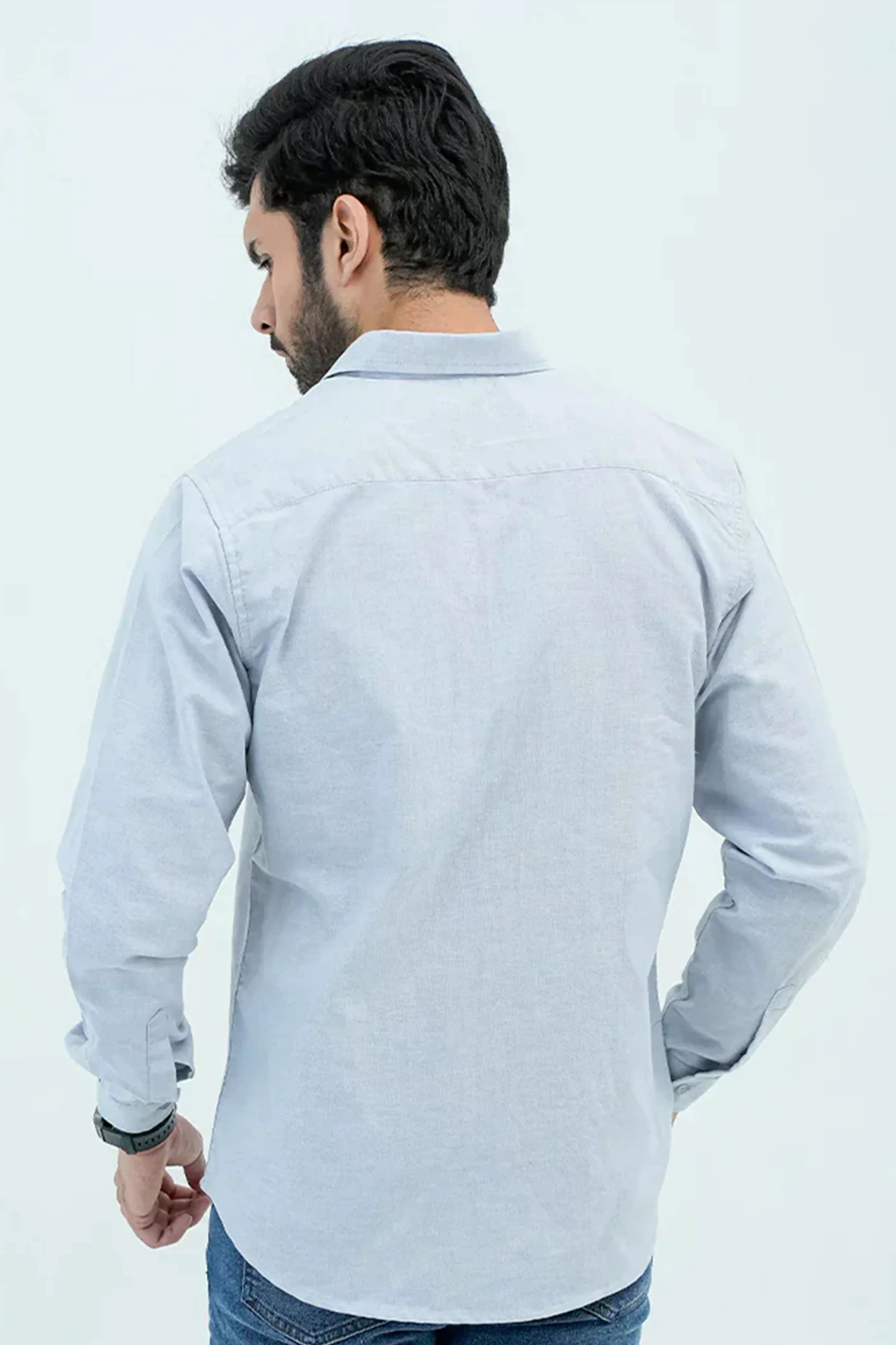 Back view of men wearing a light blue Oxford shirt