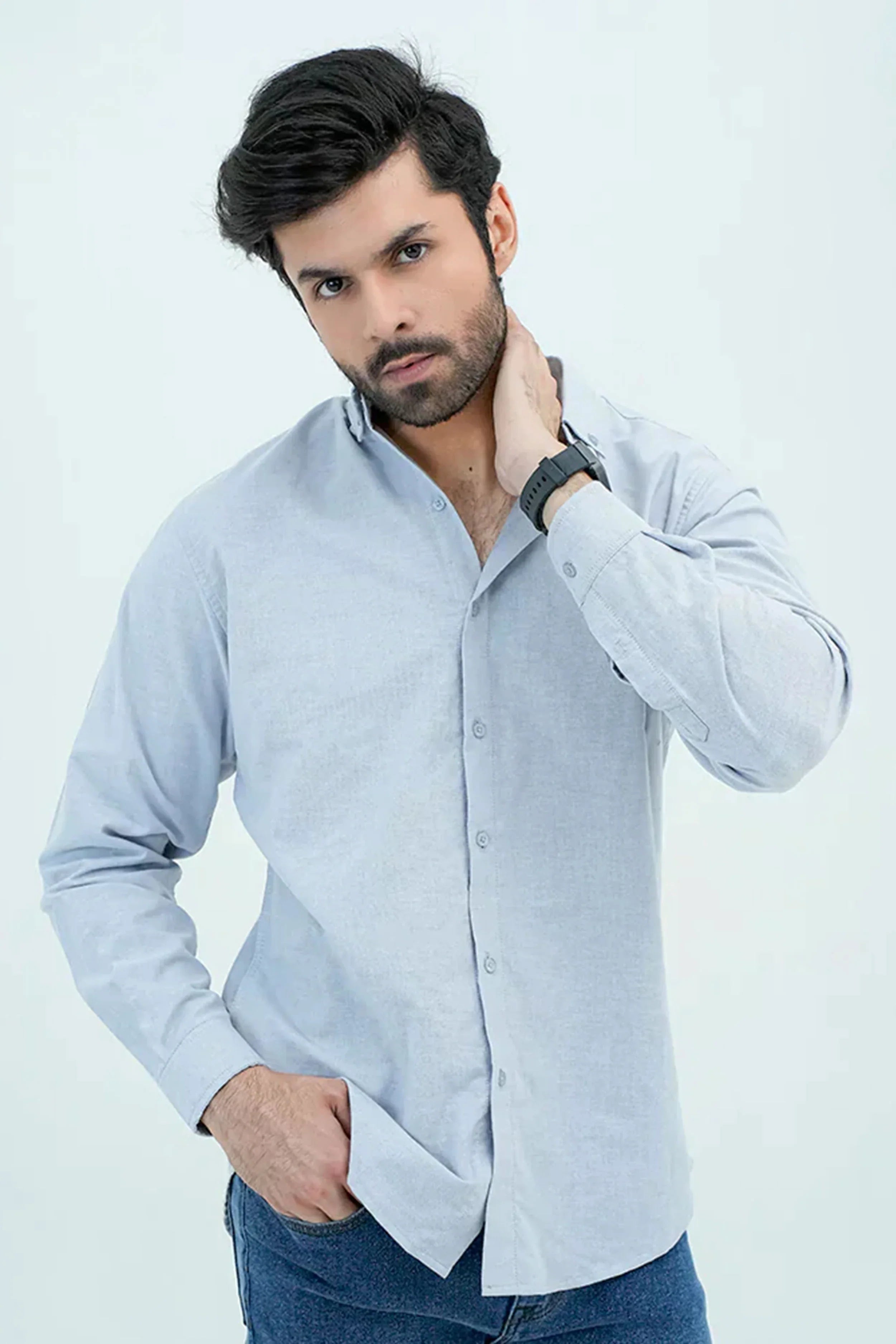 Man wearing a light blue Oxford shirt with button-down design