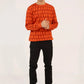Men wearing Men Red Geometric Sweatshirt styled with black pants in studio