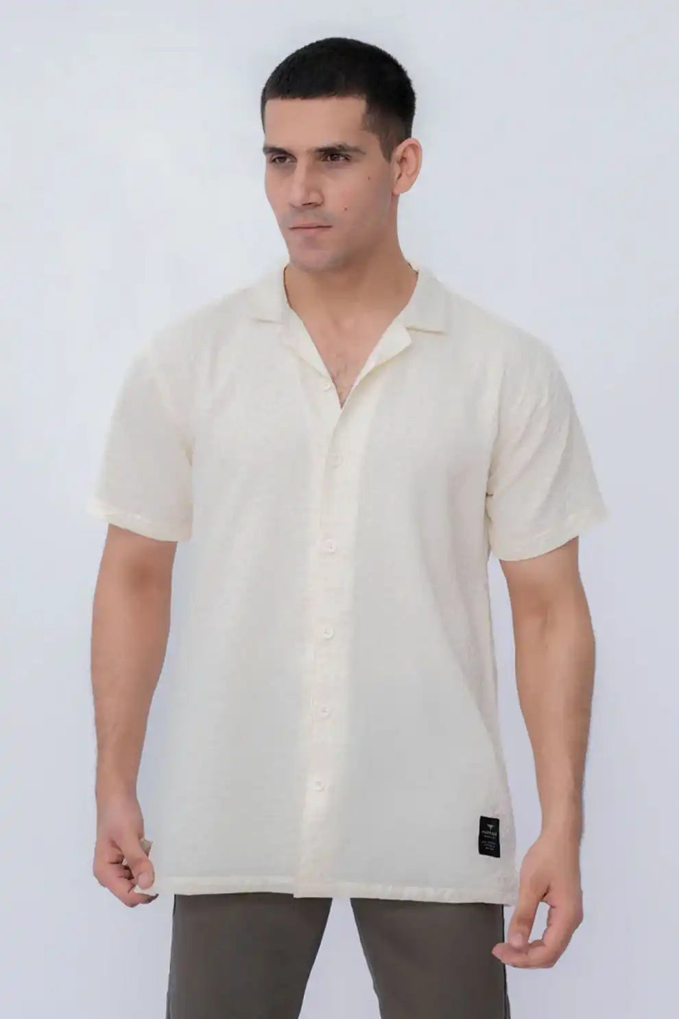 Model wearing a beige short-sleeve shirt 