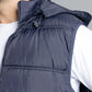 Navy blue puffer vest worn by a person on a gray background
