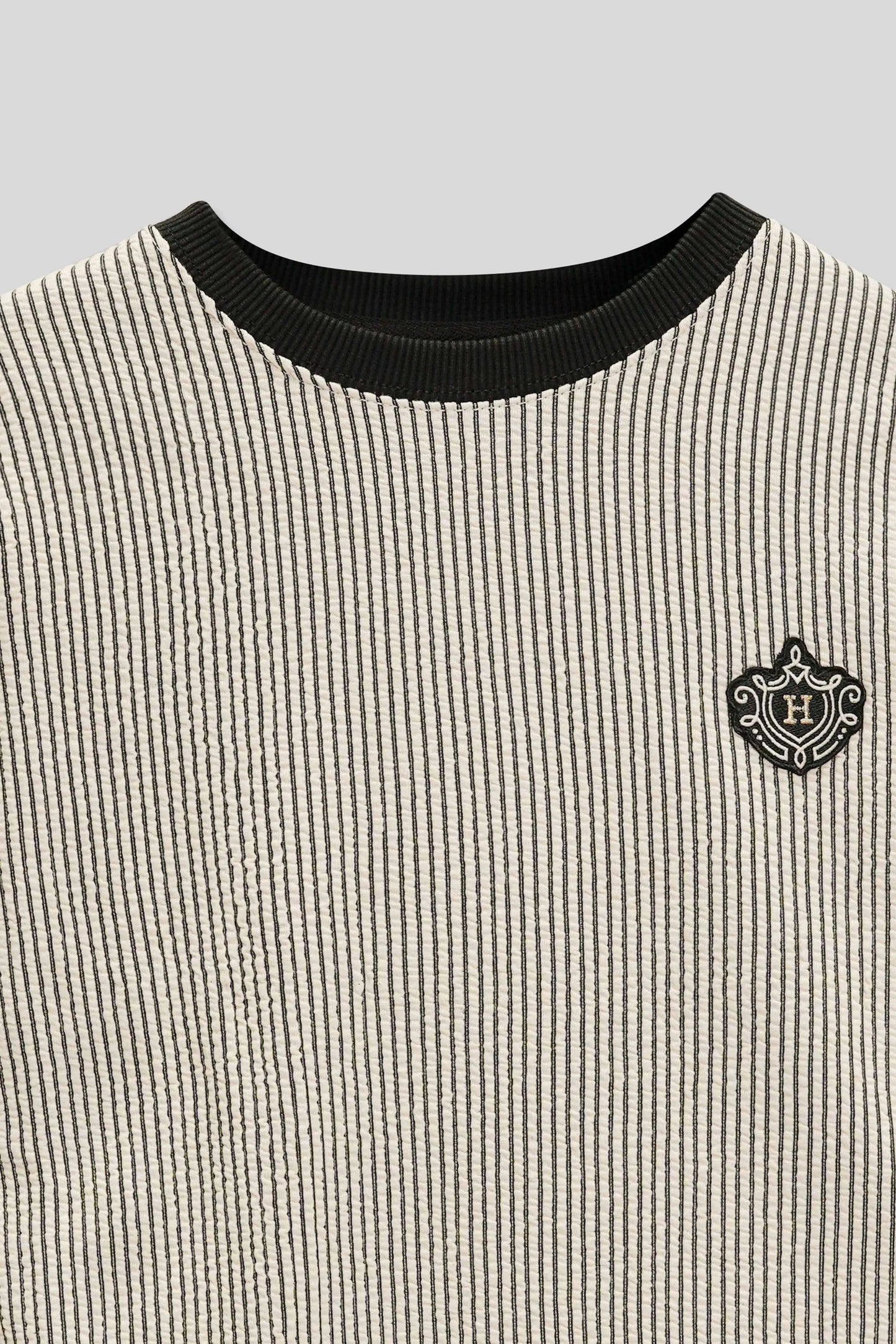 Neckline and chest area detail with logo on a patterned sweatshirt