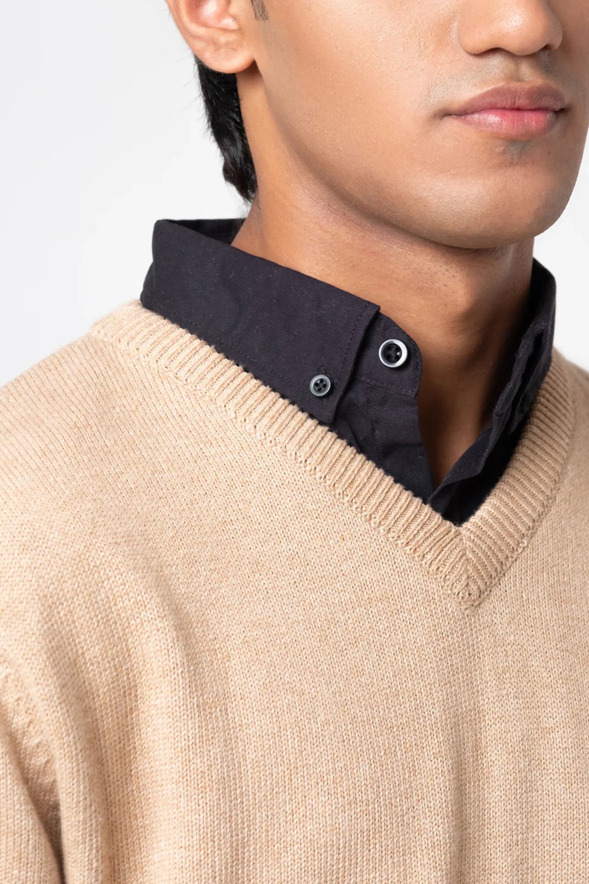 Neckline close-up showing layered collar under beige cardigan