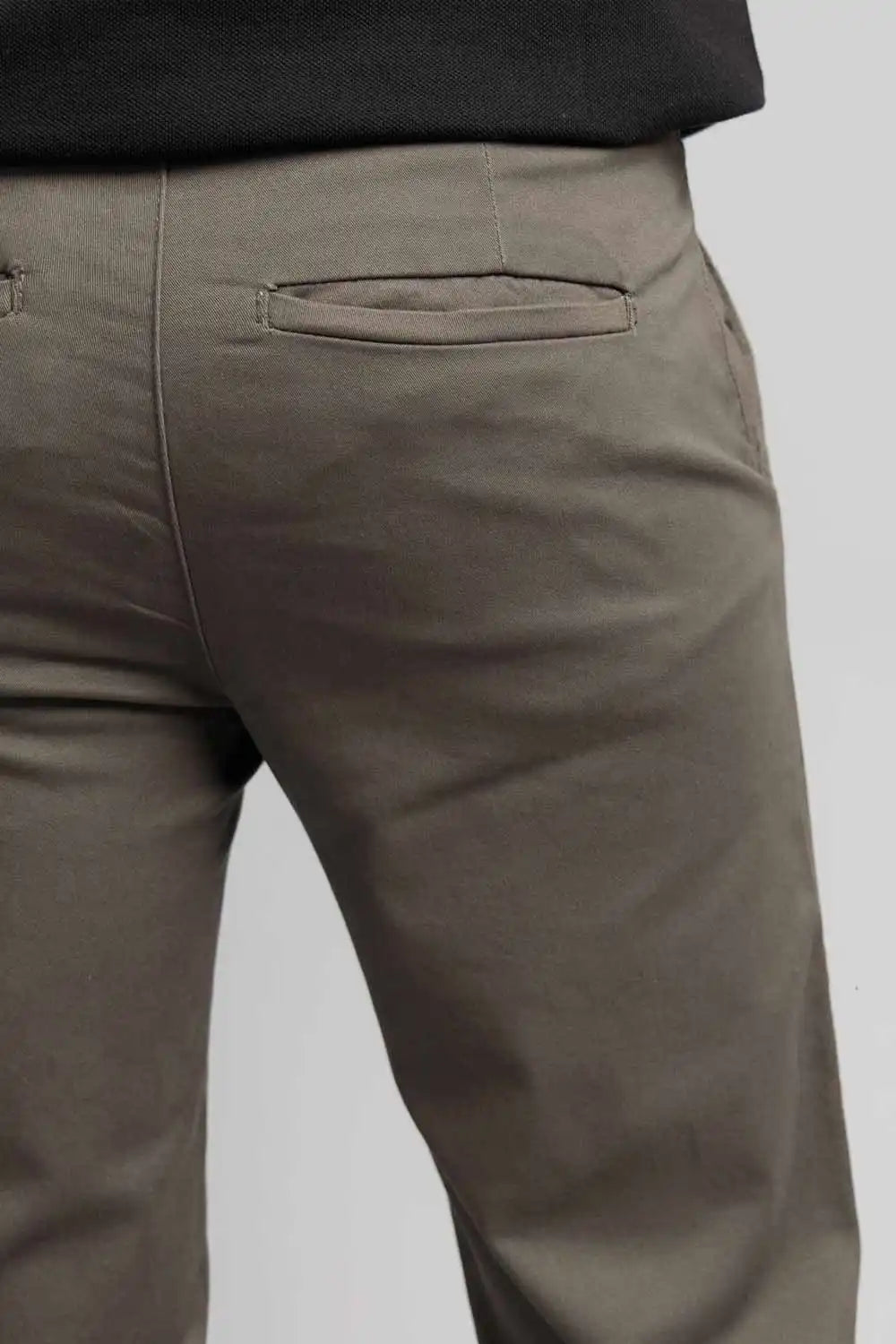 Close-up of olive green pants on a plain background
