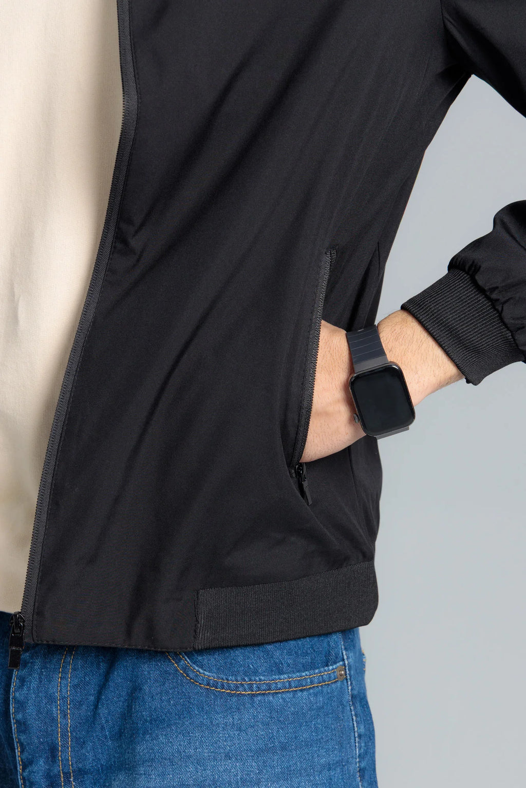 Person wearing a black jacket with a gray background