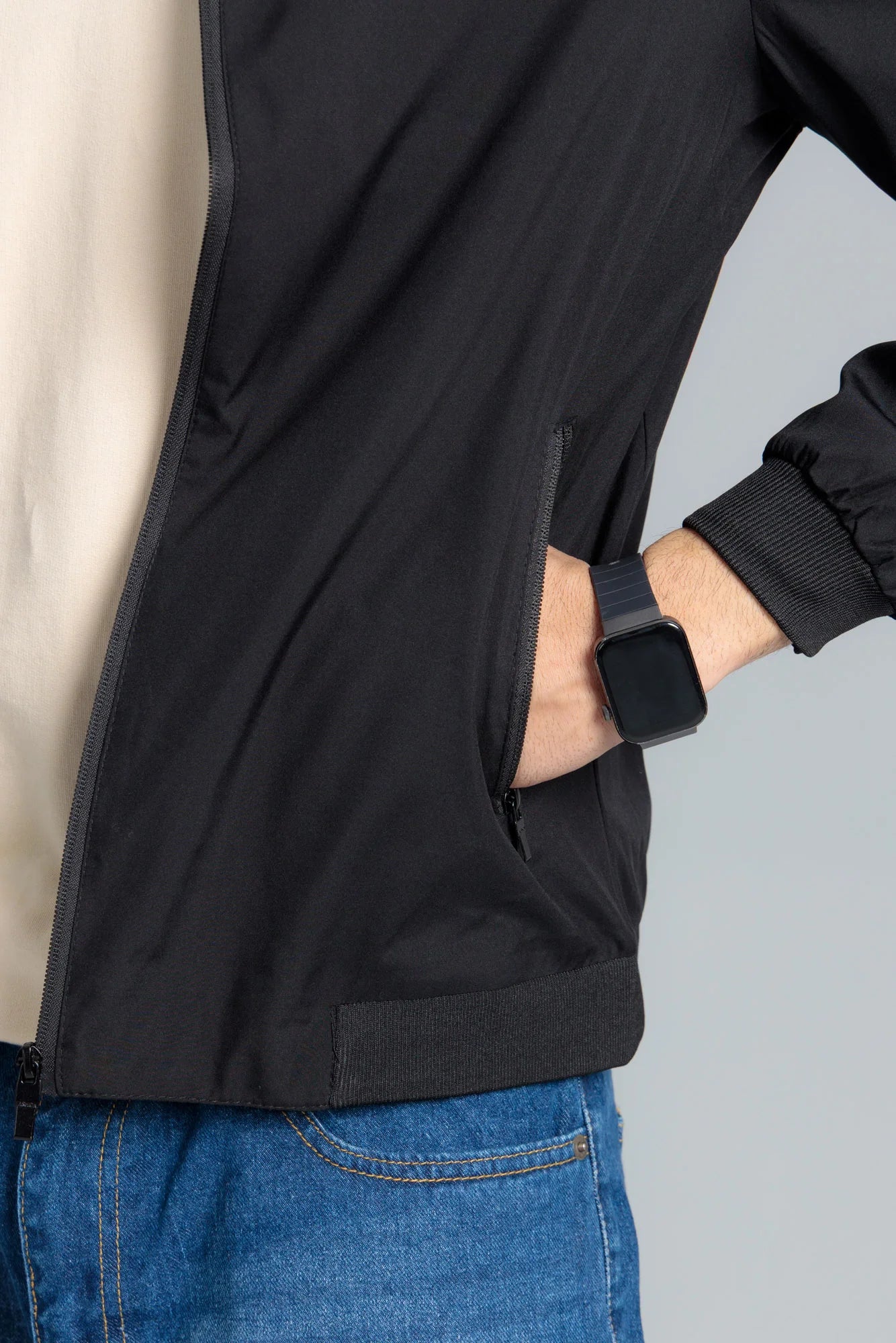 Person wearing a black jacket with a gray background