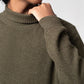 Person wearing a brown sweater against a light background