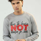 Person wearing a gray sweatshirt with motivational text on a plain background
