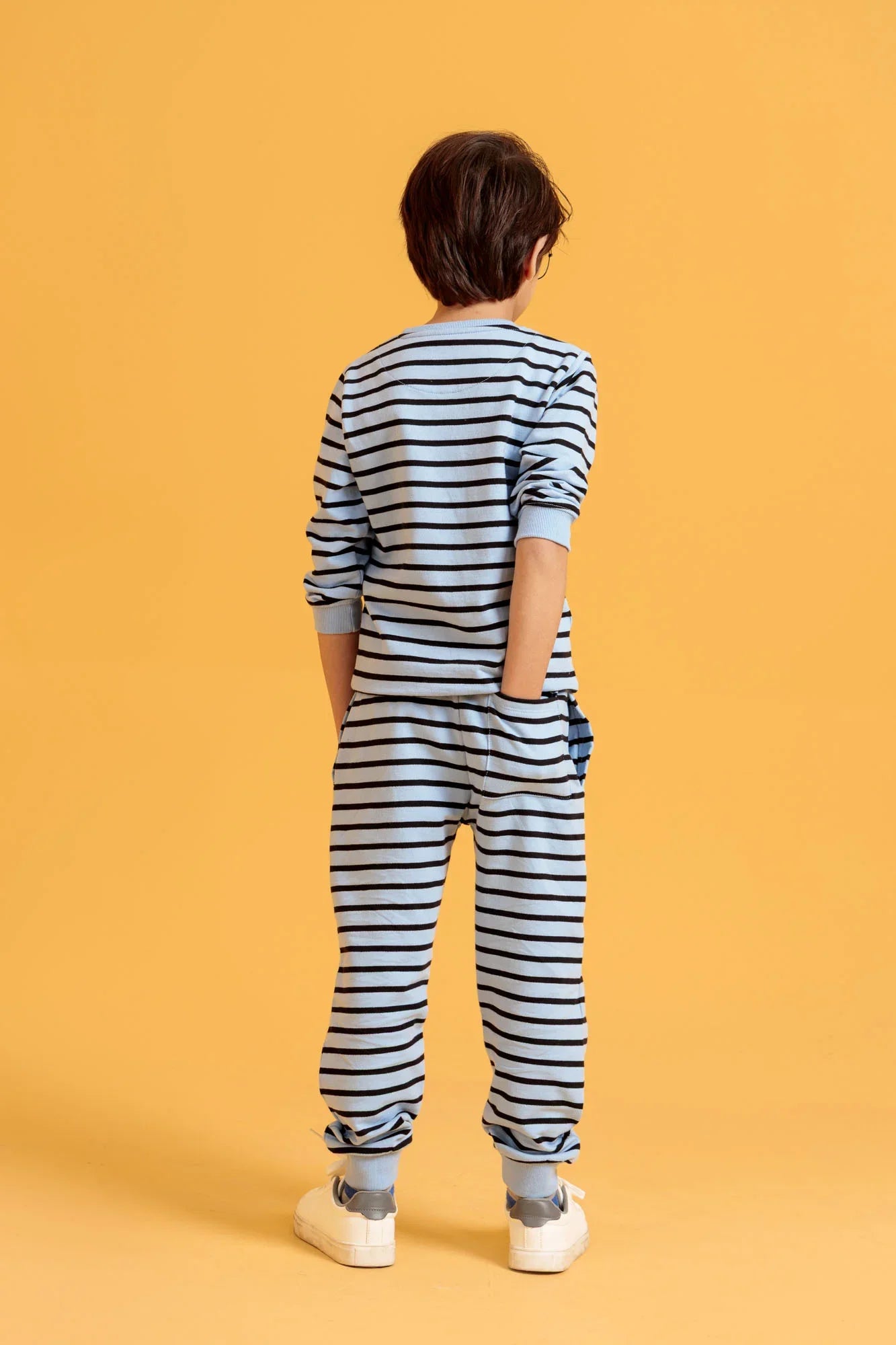 Person wearing a striped outfit on an orange background