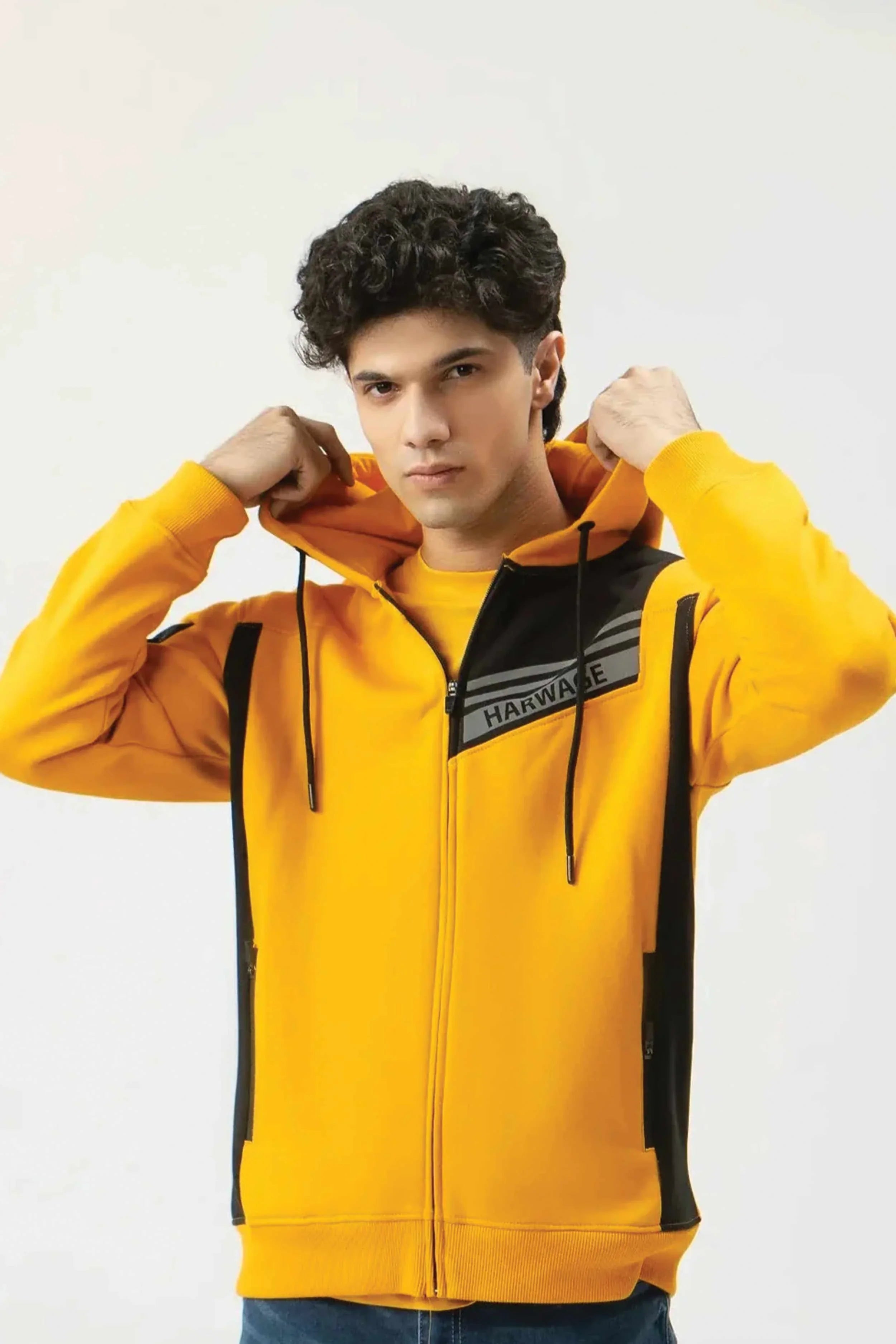 Person wearing a yellow and black jacket with 'Havaianas' branding on a white background
