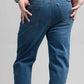 Person wearing blue jeans on a plain background