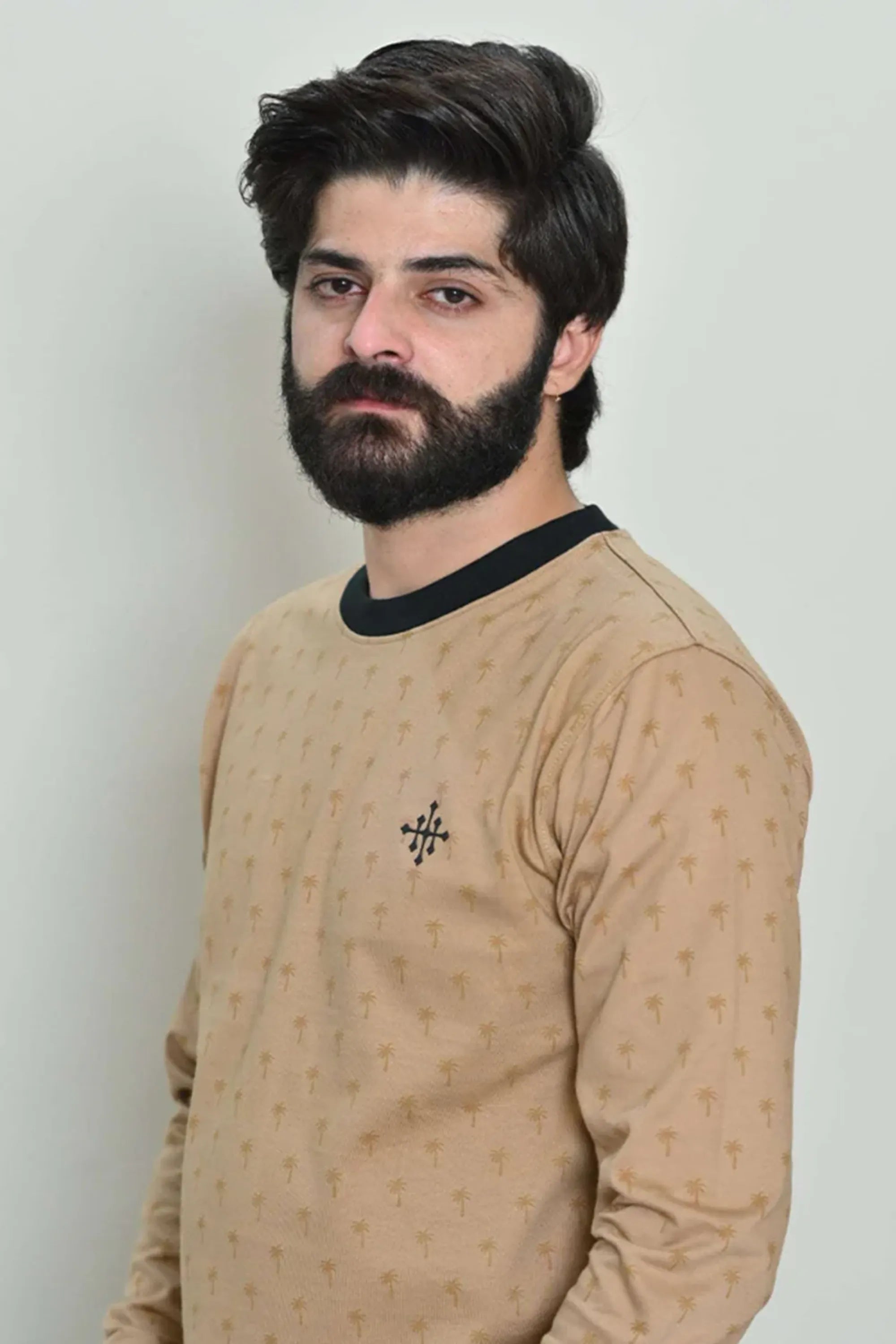 Profile pose featuring a beige palm-rotary design sweatshirt on the wearer
