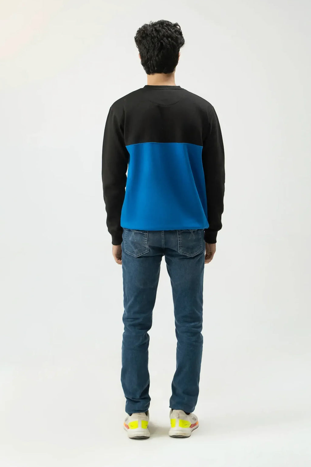 Rear standing view of Blue Signature Sweatshirt worn with jeans