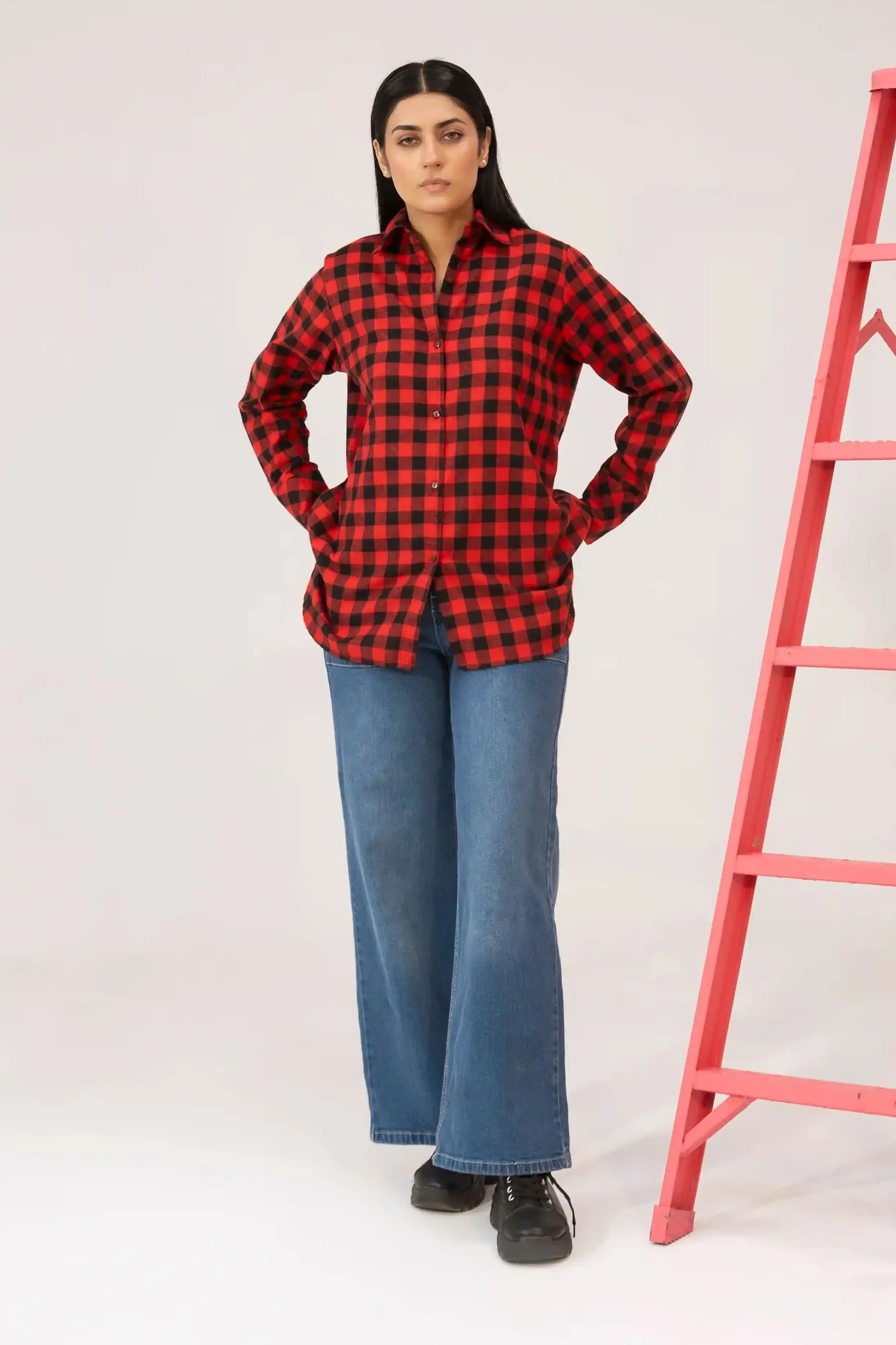 Girl wearing a red and black checkered shirt and blue jeans