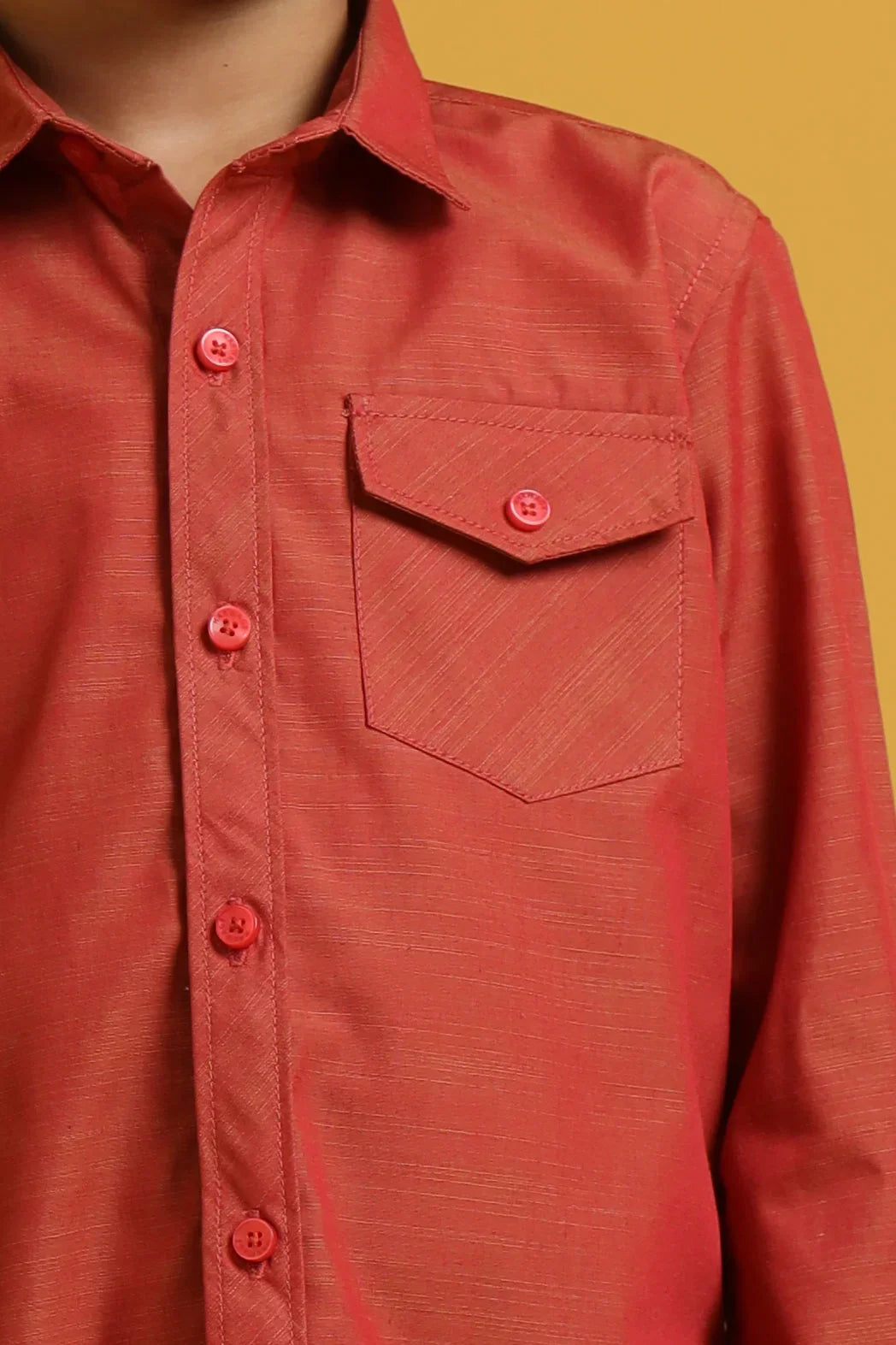 Red button-up shirt with a pocket on a yellow background