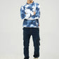 Relaxed full-body pose wearing blue tie-dye patterned sweatshirt