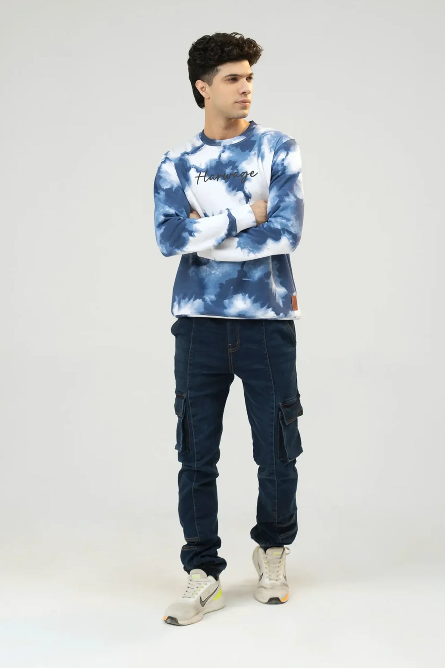 Relaxed full-body pose wearing blue tie-dye patterned sweatshirt