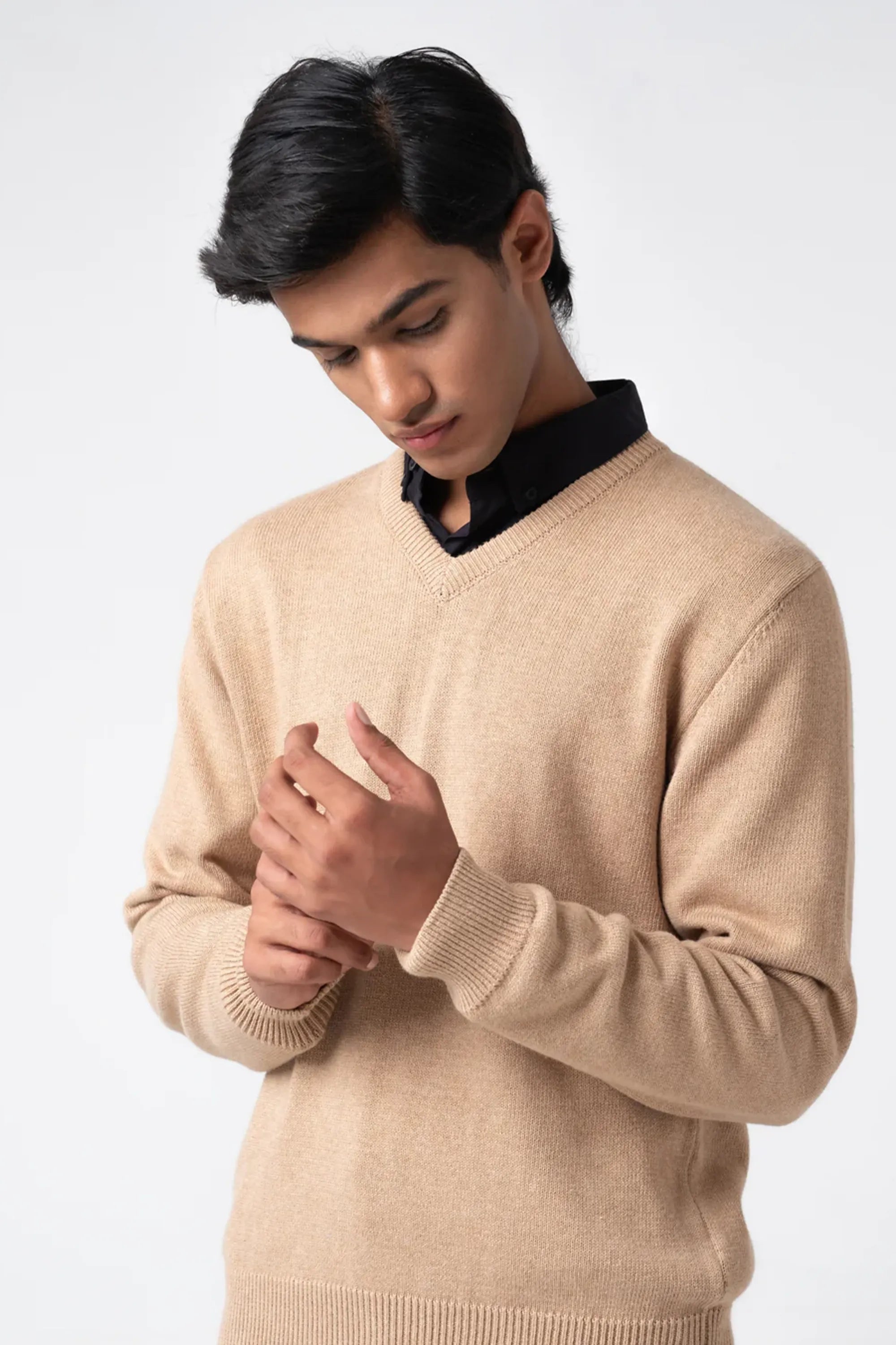 Beige V-neck cardigan worn with black shirt showing cuff detail