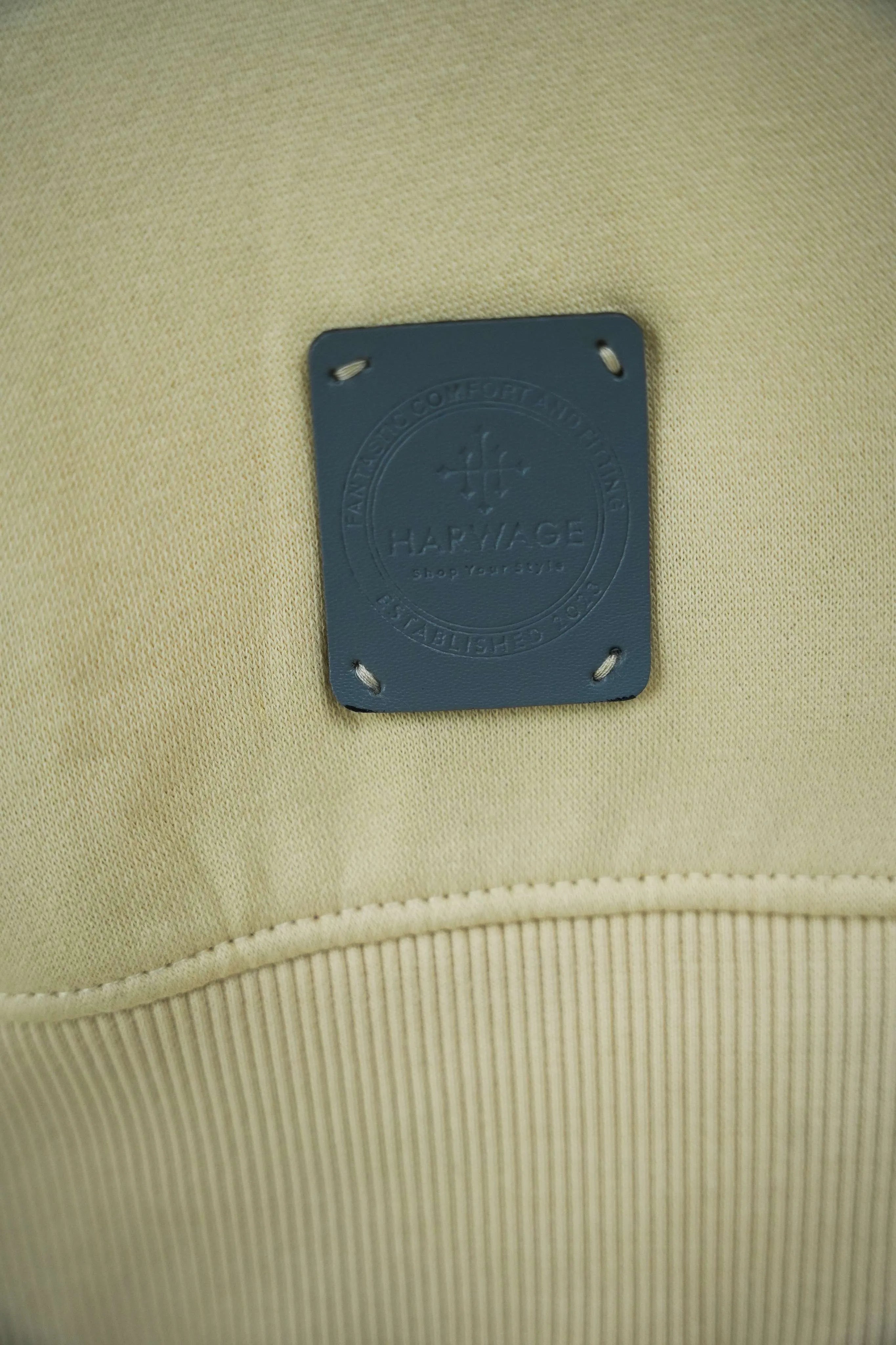 Ribbed cuff and hem detail on a cream cotton sweatshirt