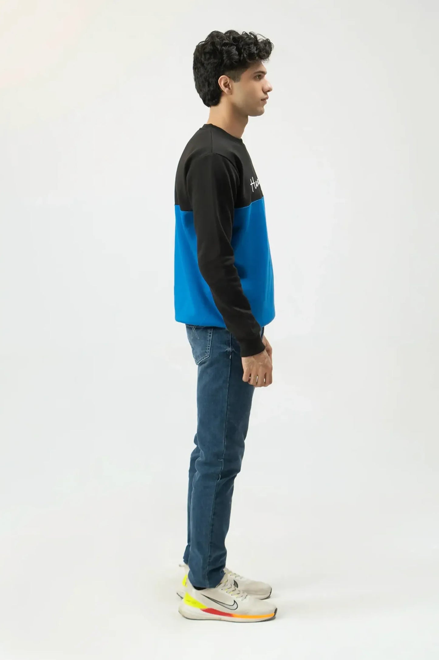 Side-on full-length angle showing fit of two-tone sweatshirt