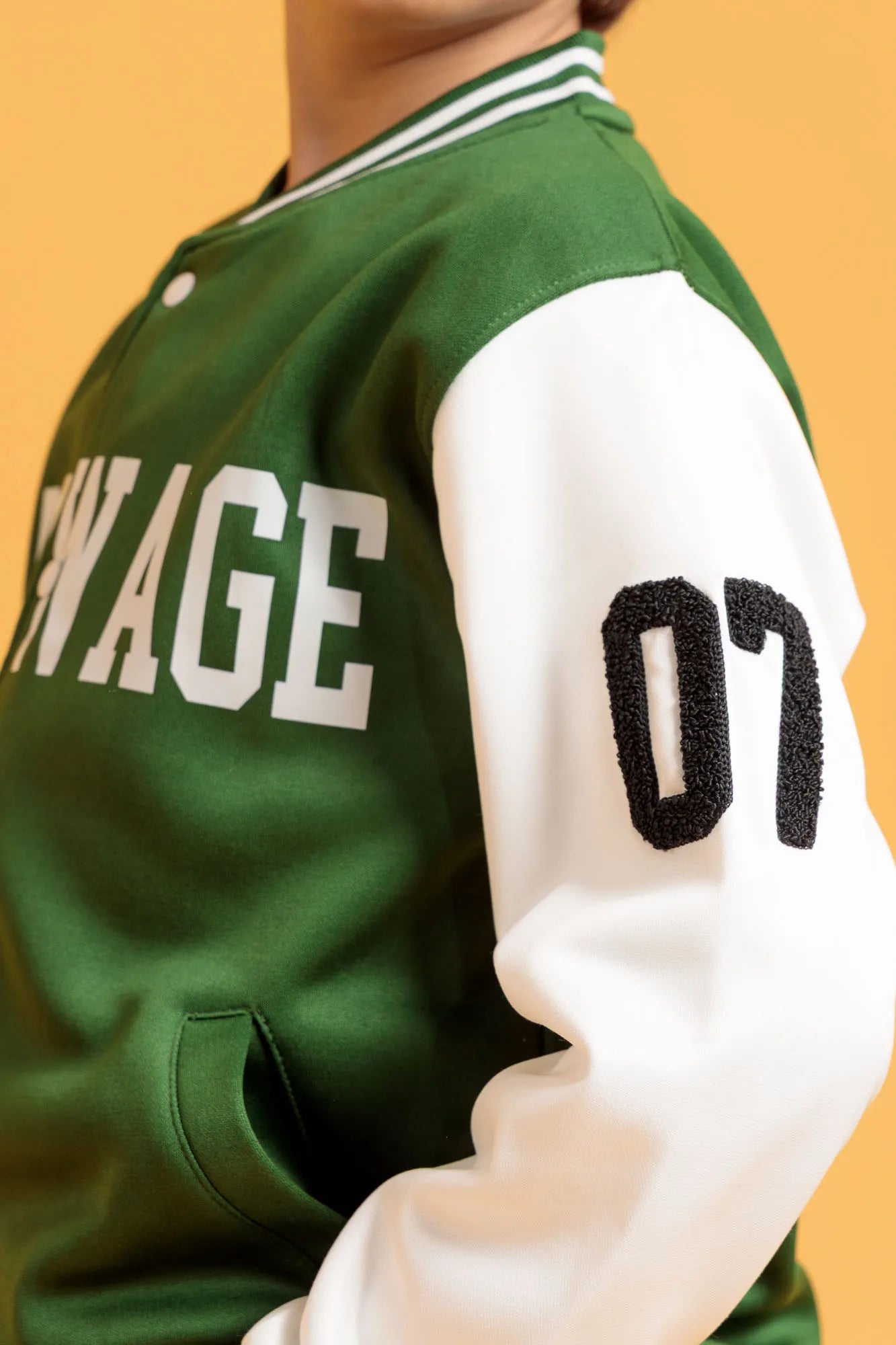 Side detail of green varsity jacket sleeve with number patch