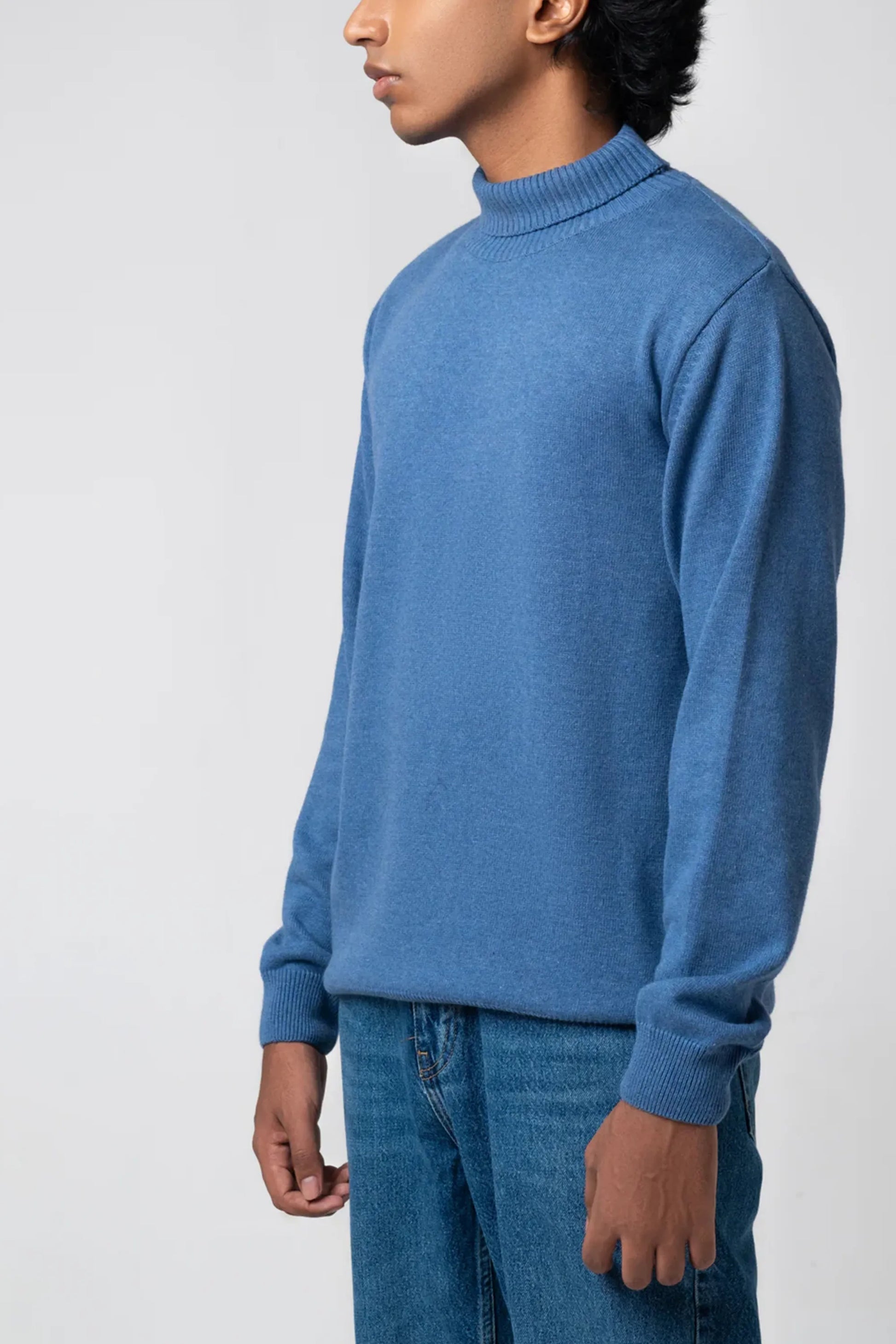 Side profile view showing fit of navy turtle neck sweater