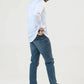 Side view of a man dressed in a light blue shirt and blue jeans