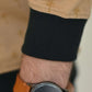 Sleeve detail with cuff finish and wristwatch on beige sweatshirt