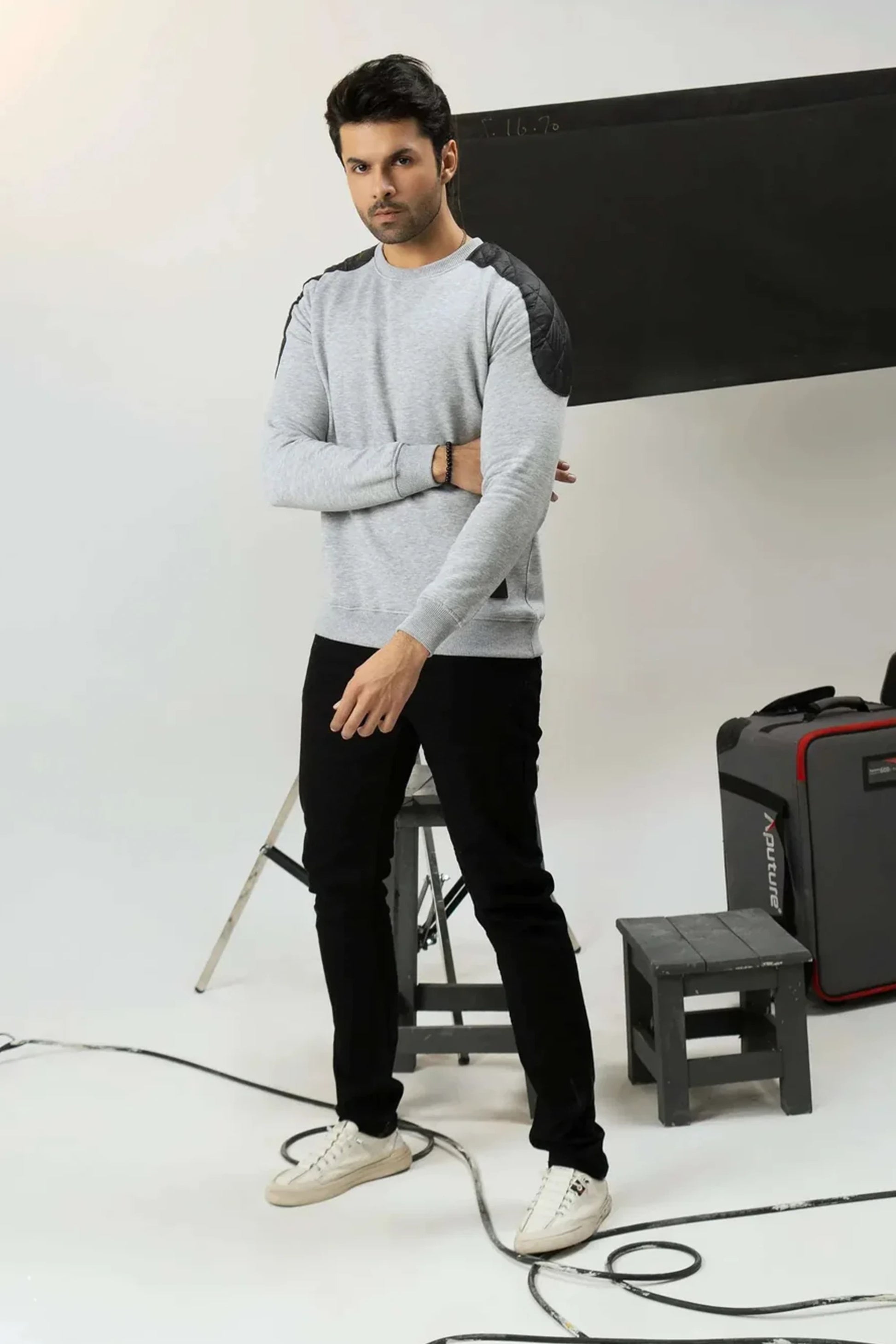 Studio shot of men’s gray crewneck sweatshirt with black shoulder
