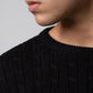 Close up texture of black cable knit sweater fabric