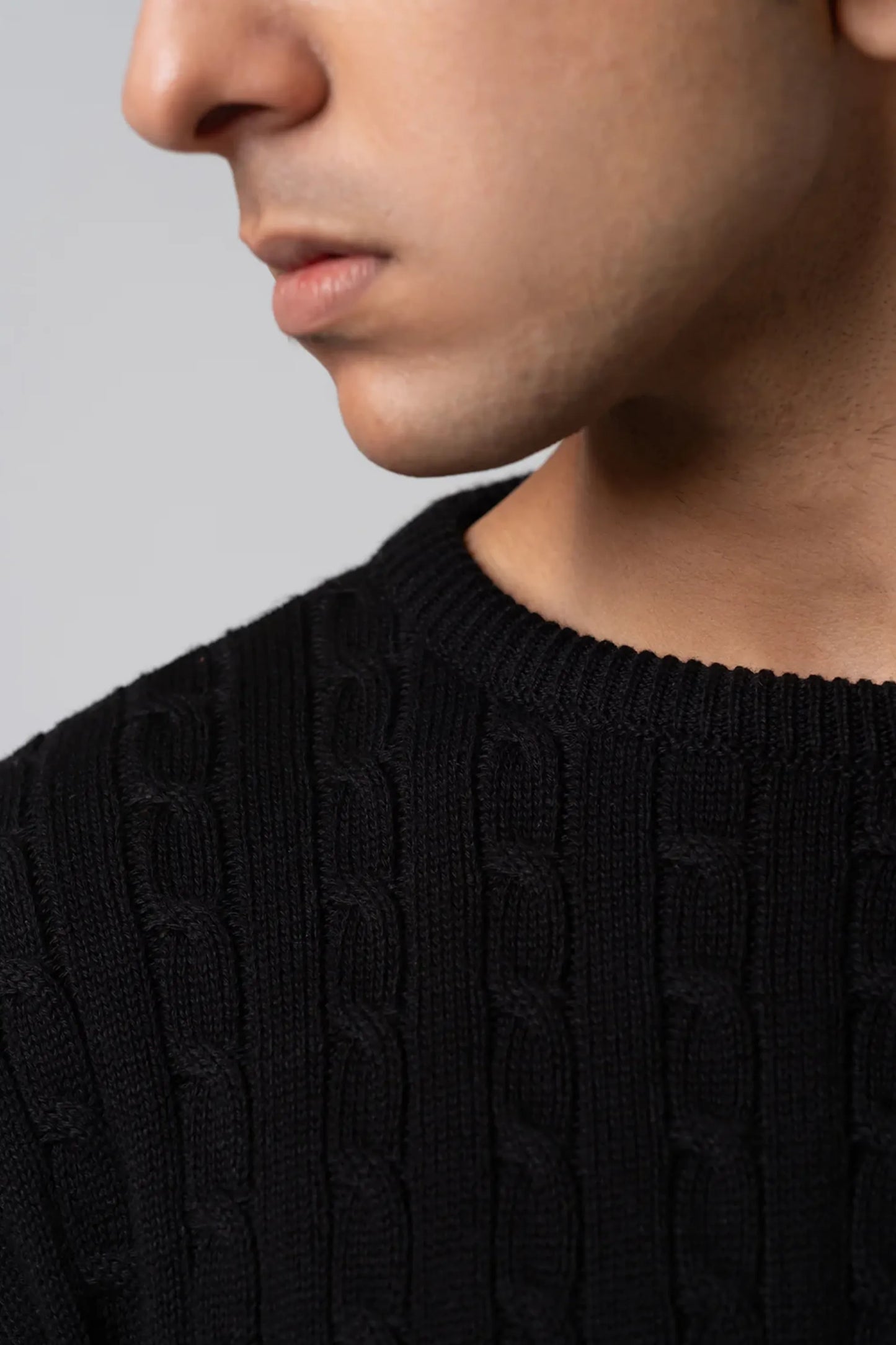 Close up texture of black cable knit sweater fabric