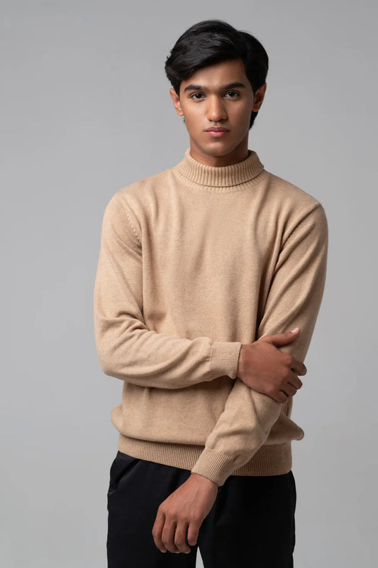 Straight view wearing turtle neck sweater beige with black trousers