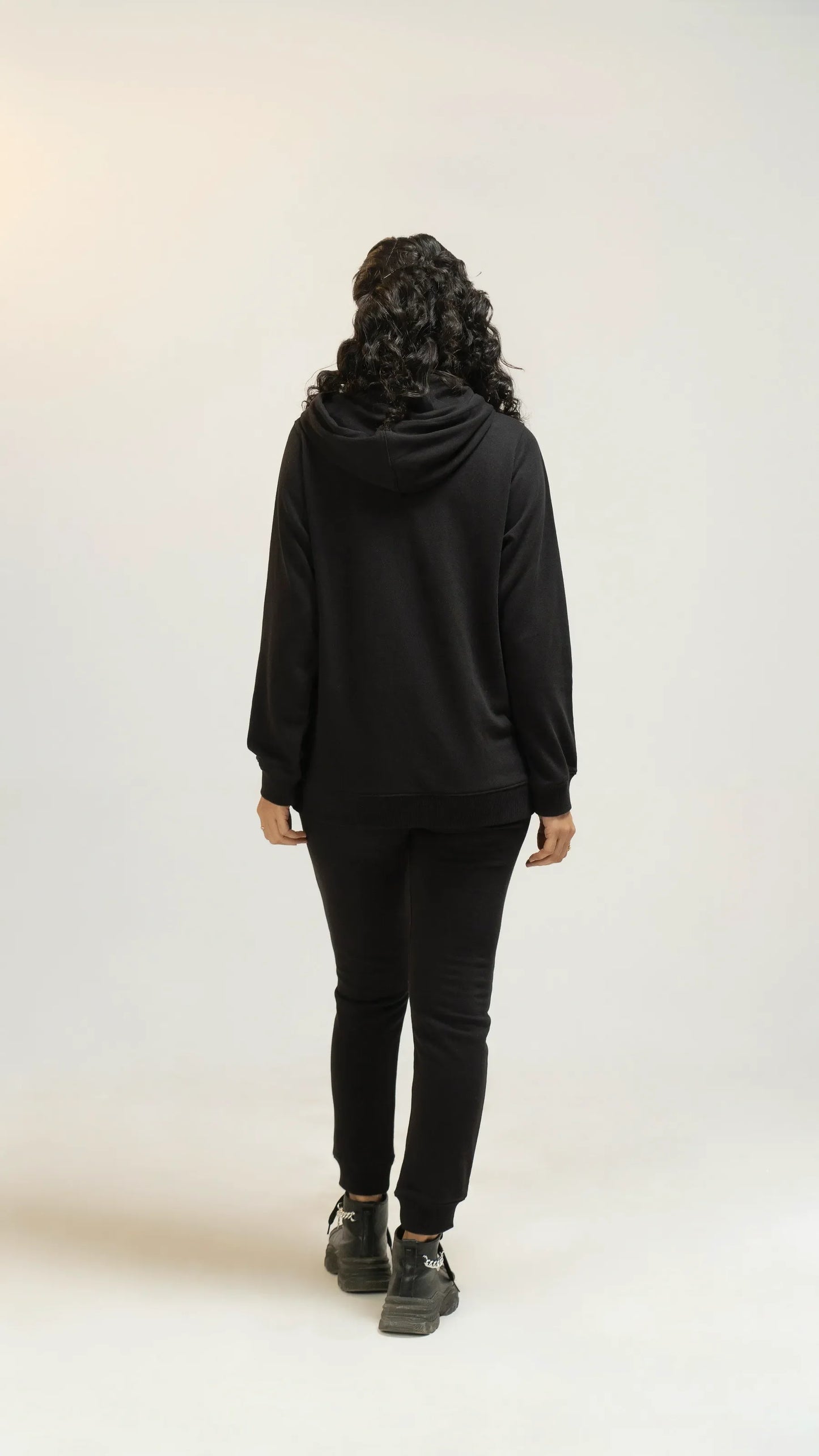 View of women’s black regular tracksuit from back side 