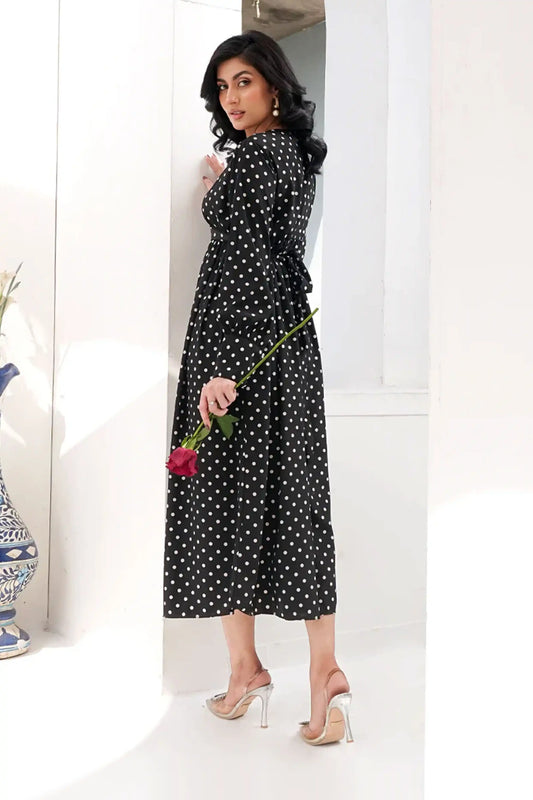 Woman in a black polka dot dress holding a red rose