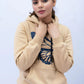 Woman styling a Beige Hoodie with a relaxed silhouette and soft finish
