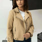 Woman wearing a beige jacket in a studio setting
