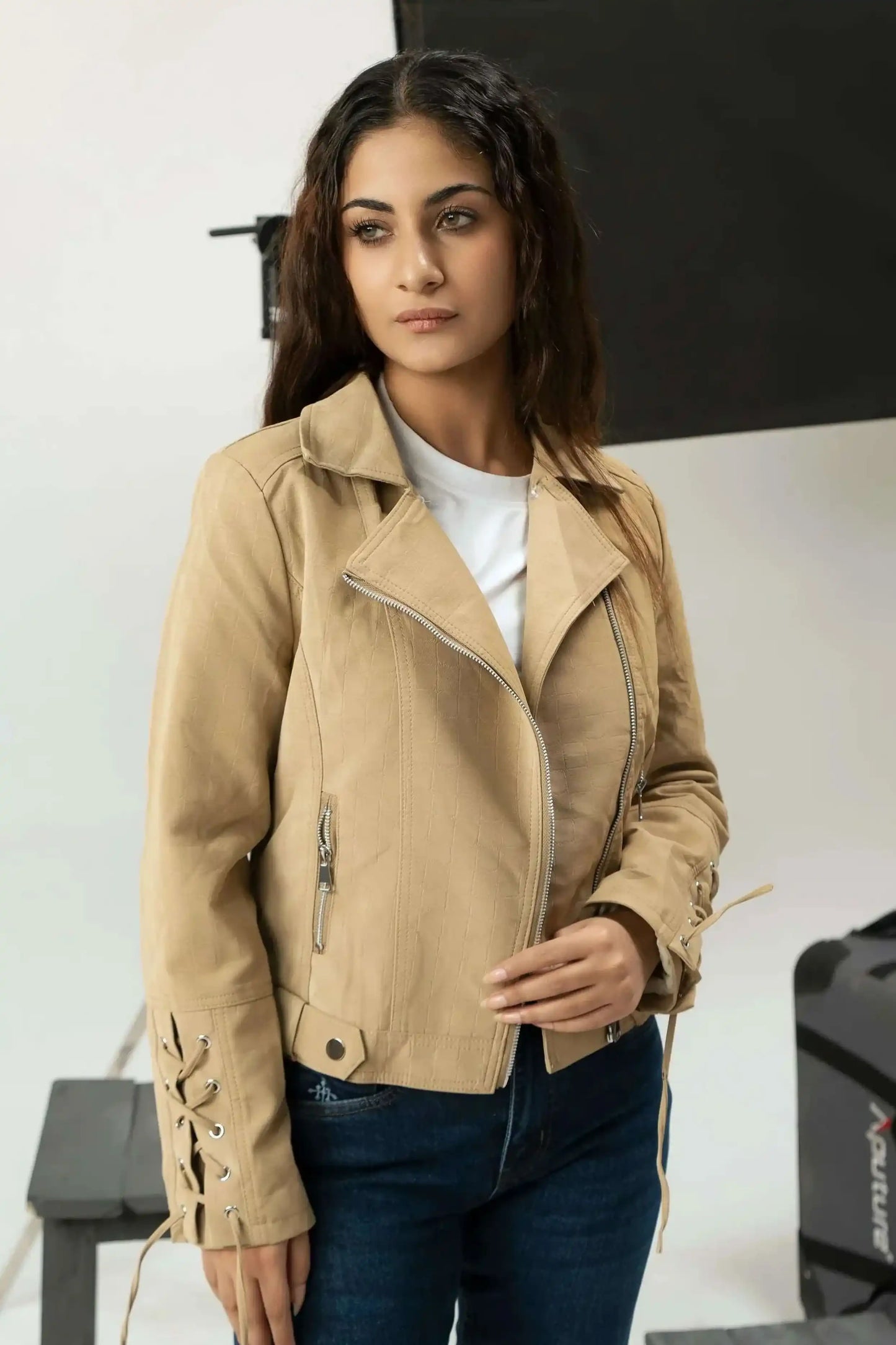 Woman wearing a beige jacket in a studio setting
