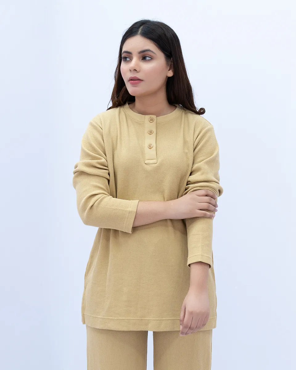 Woman wearing a beige kurta with a plain background